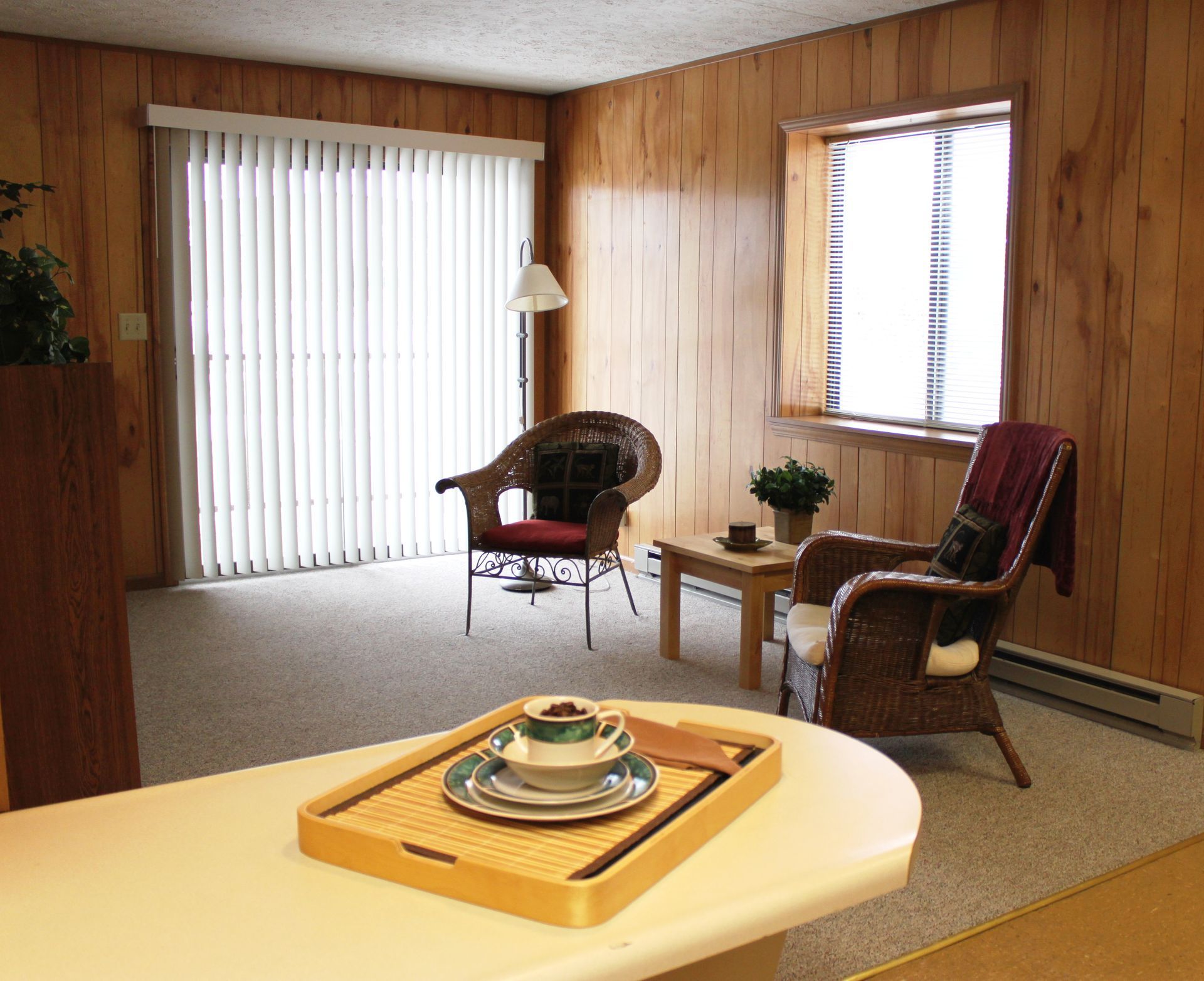 Photo showing a living room with patio and a wall with a large window