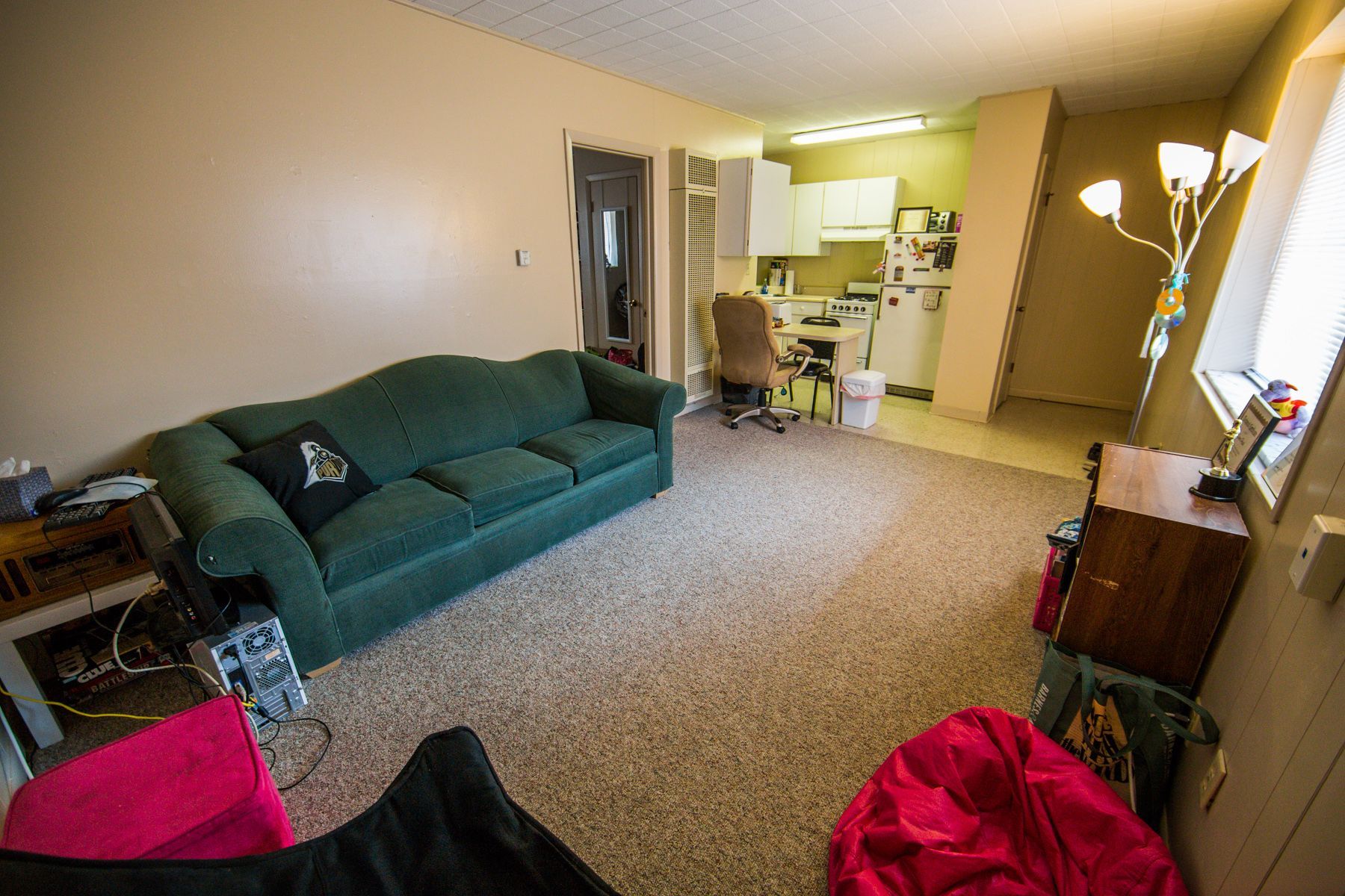 Photo showing a photo of a kitchen in the background and a living room in the foreground