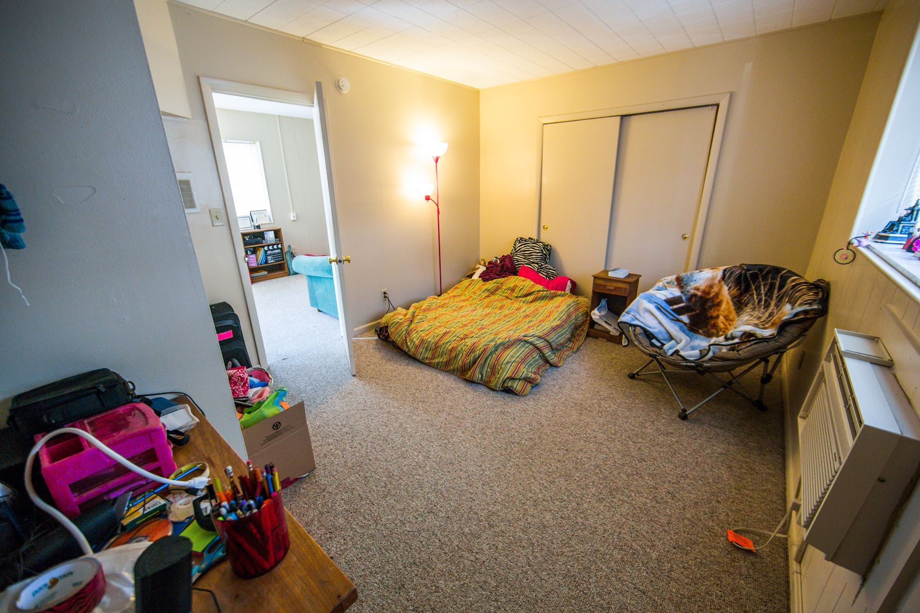 Photo showing a bedroom with a living room in the background