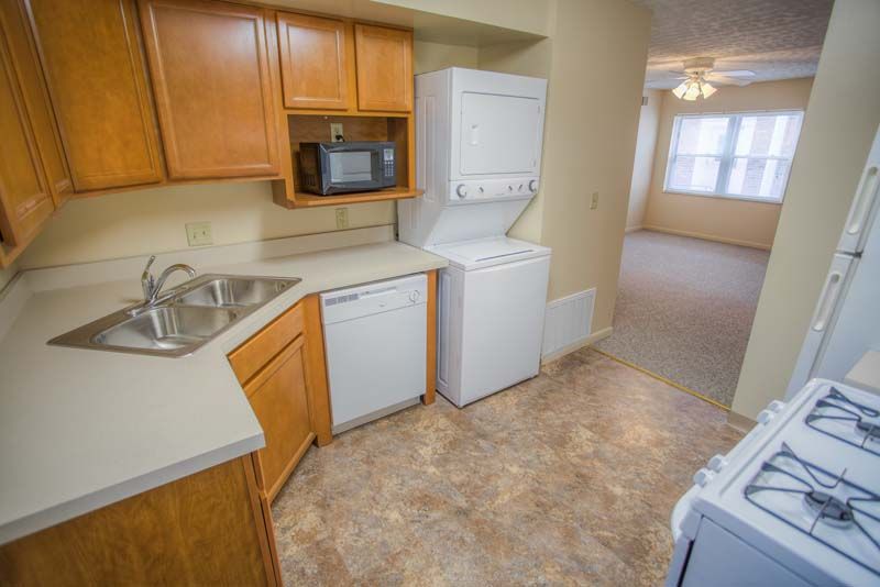 Photo showing a kitchen with a living room in the background
