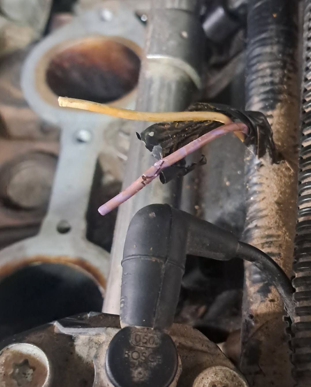 Close-up of exposed electrical wires and connectors inside a vehicle engine compartment