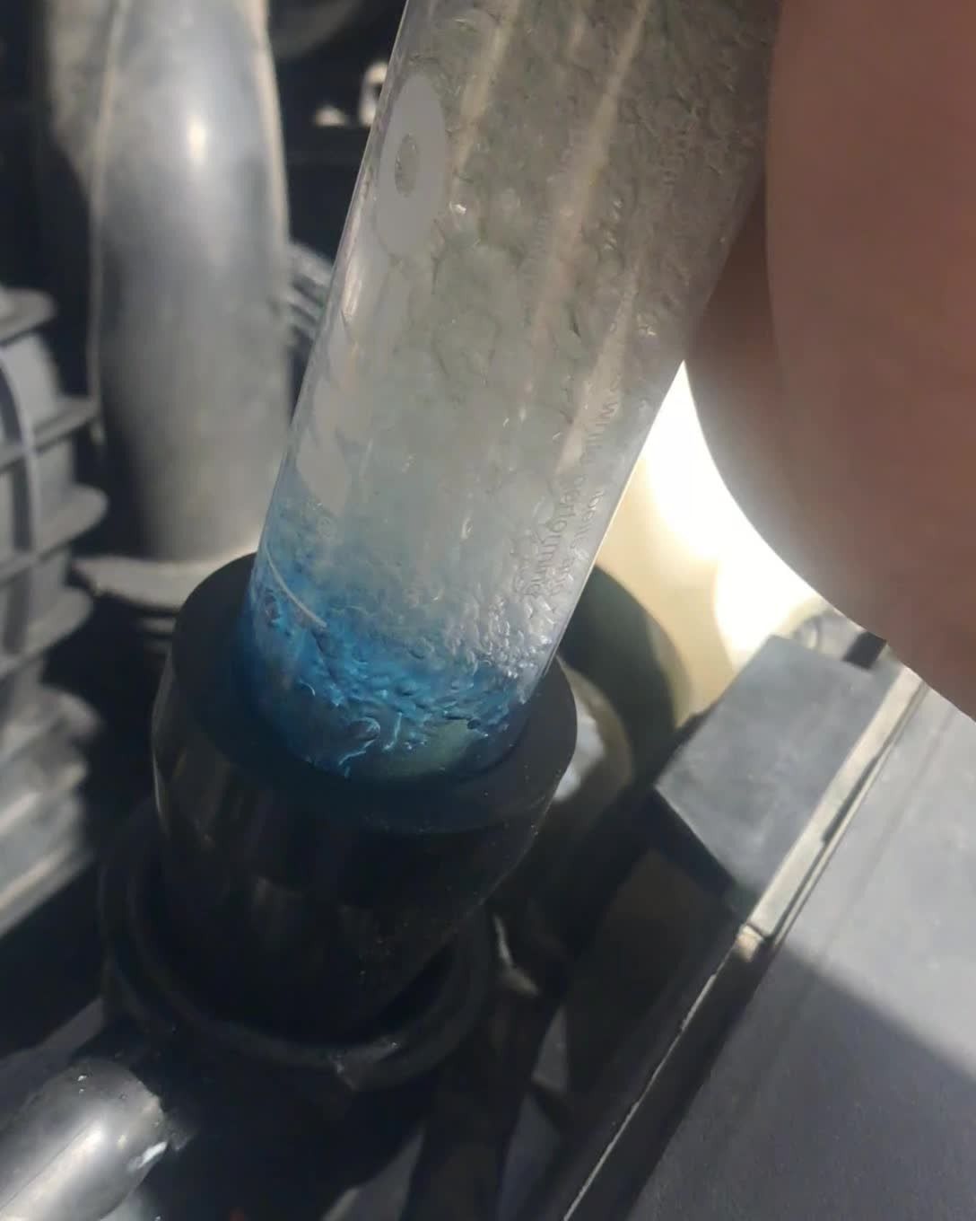 Close-up of a blue-tipped clear tube inserted into a black plastic fitting.
