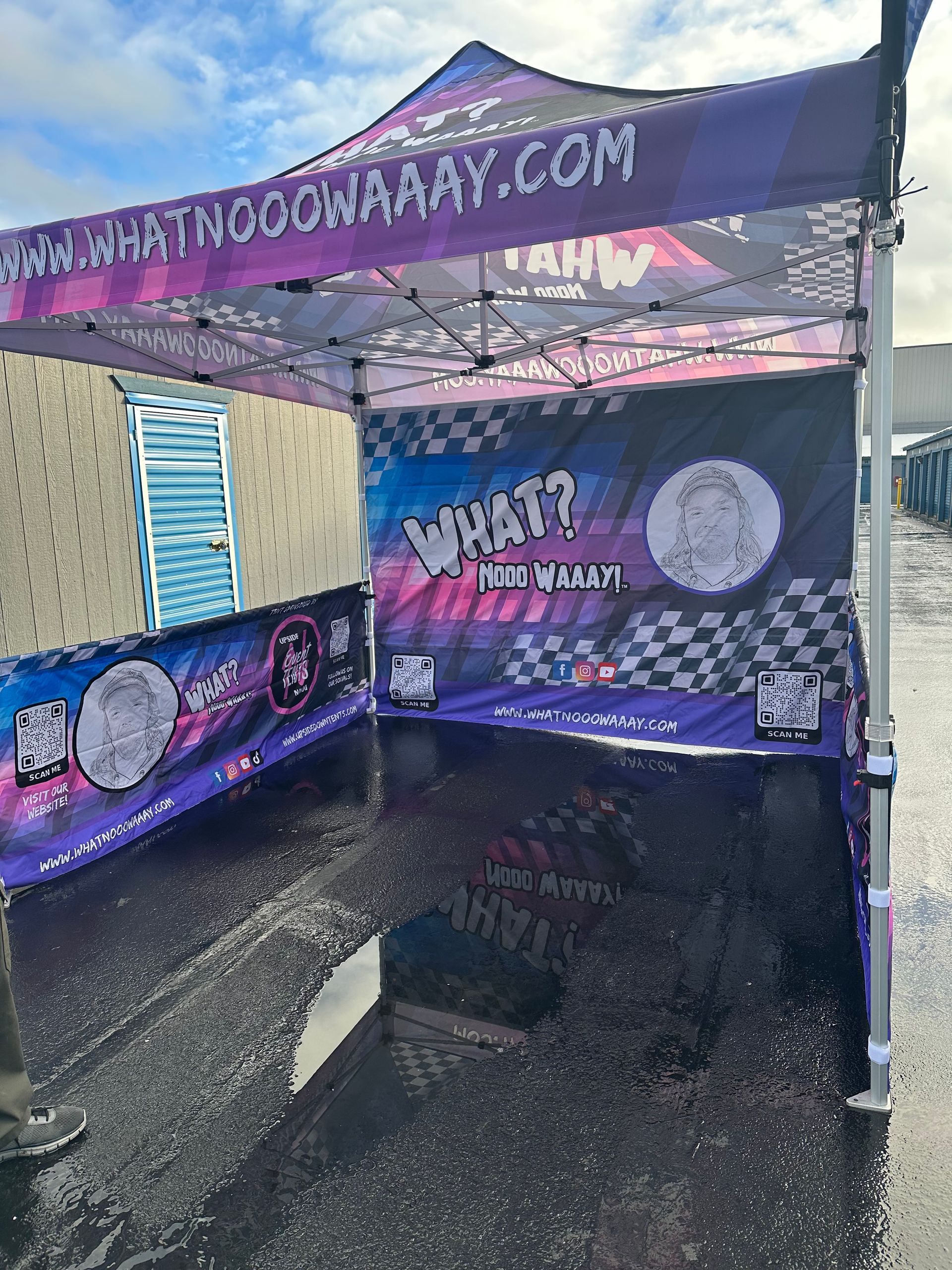 UpsideDown booth at a trade show, with staff greeting visitors under a white-and-blue canopy.