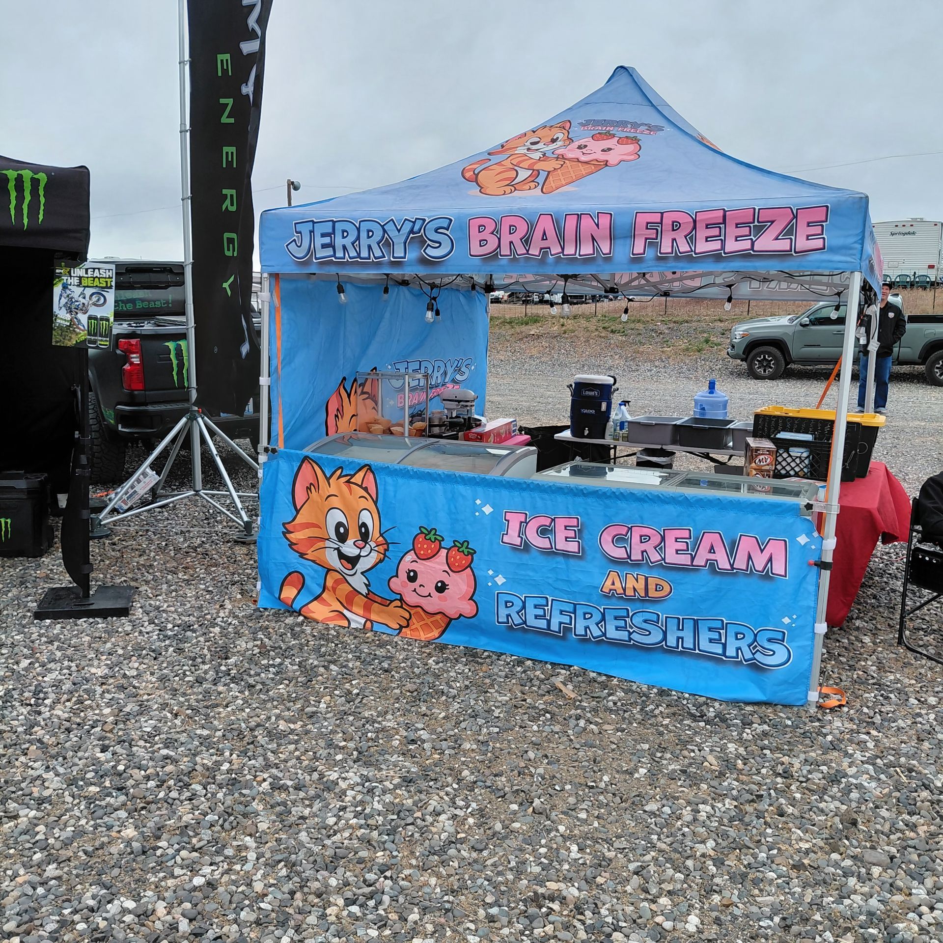 Blue “Benny’s Brain Freeze” ice cream and refreshers booth at an outdoor event.