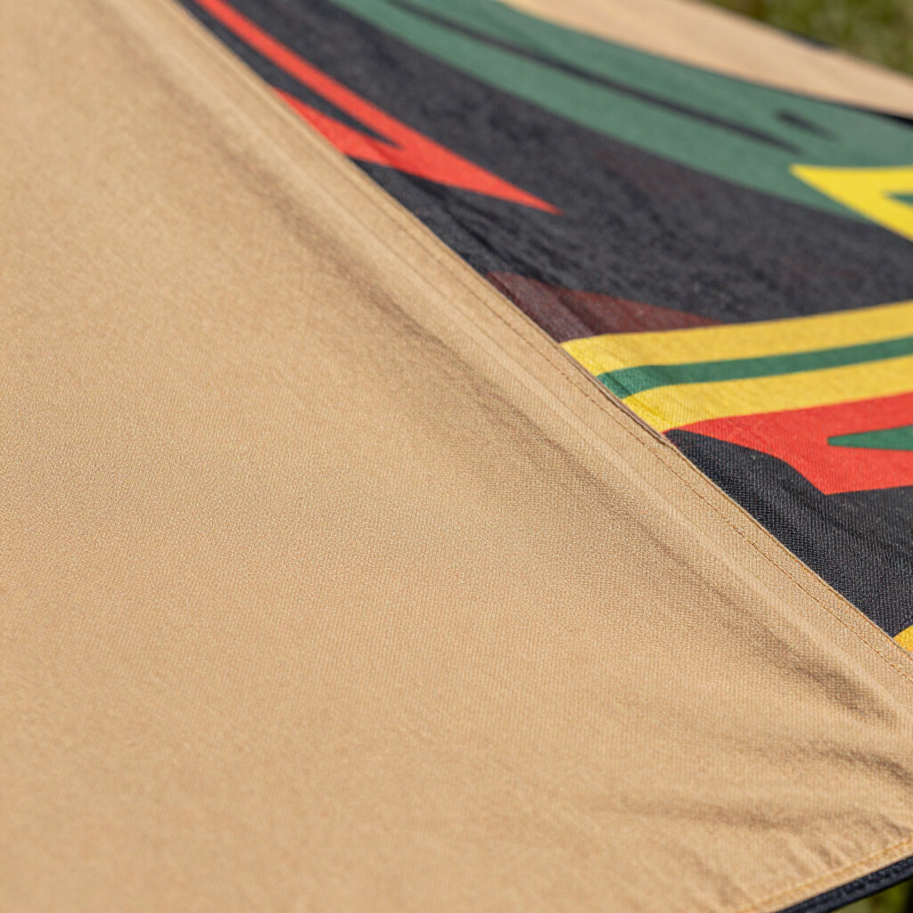 Close-up of tan fabric with a colorful geometric patterned edge and a red arrow accent