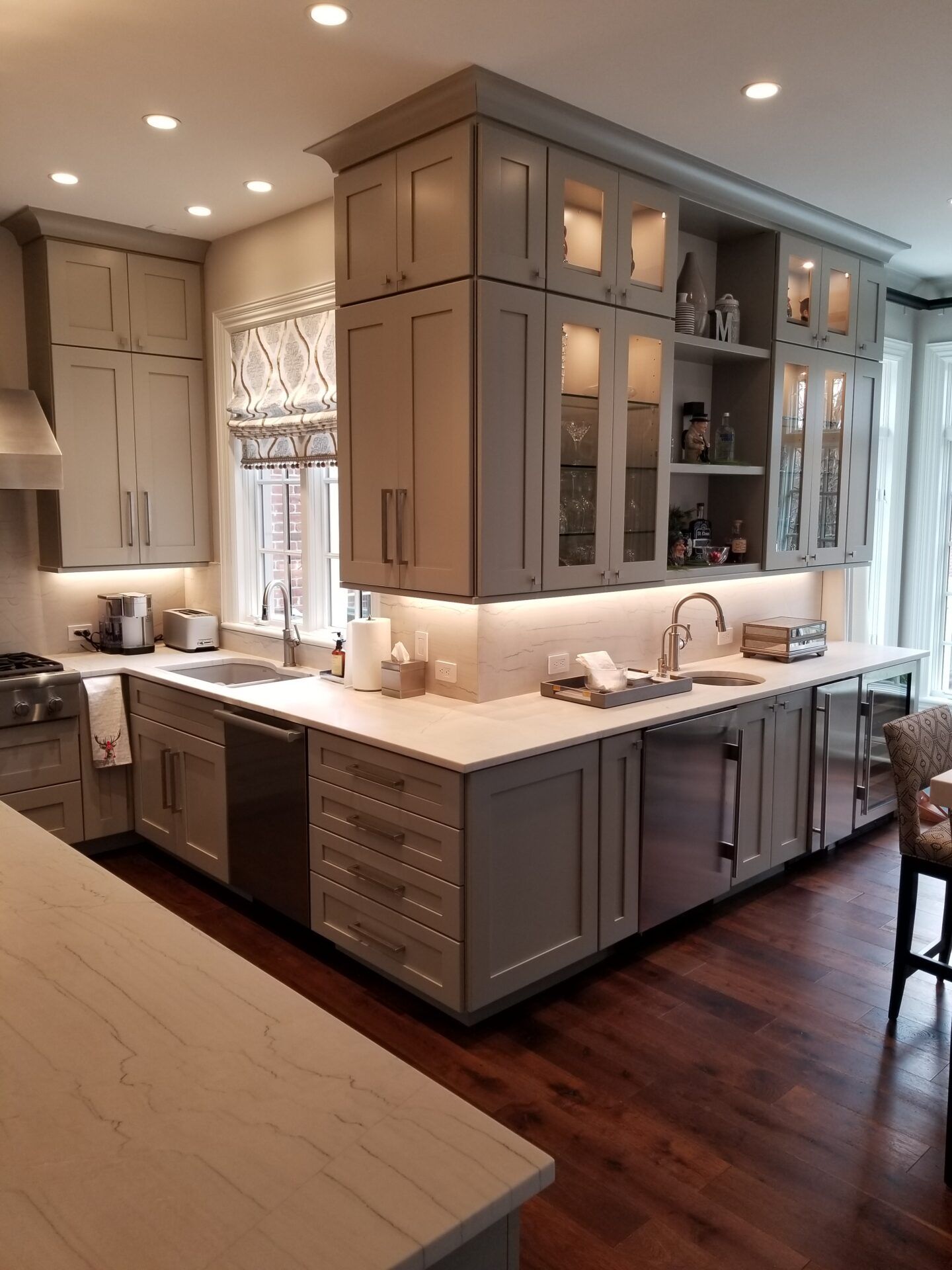Gray kitchen with cabinetry, stainless steel appliances, and wood flooring.