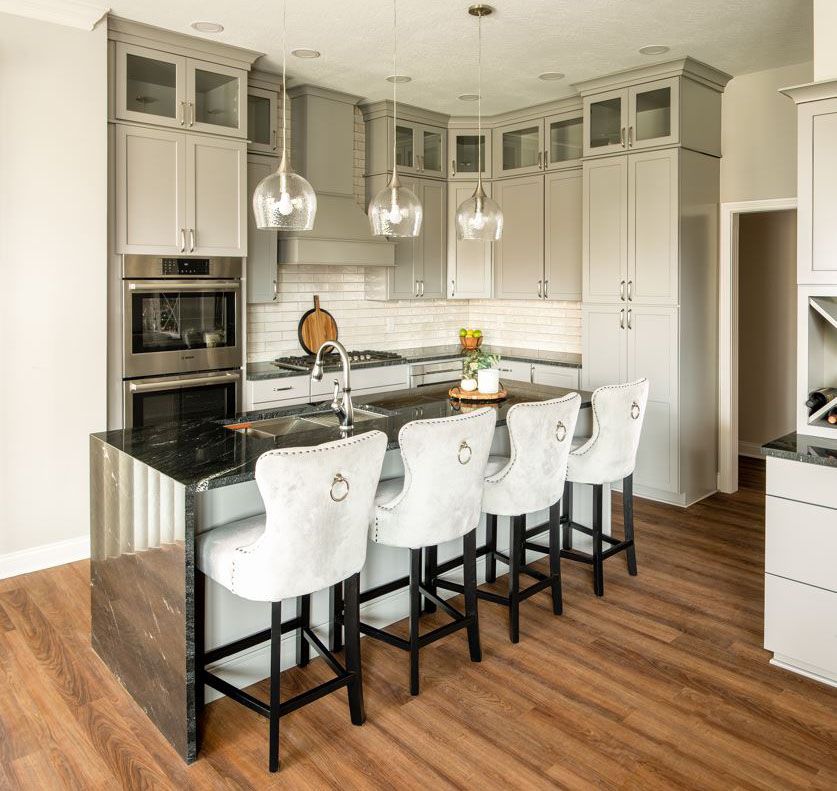 Gray and stainless steel kitchen with island seating and pendant lights.