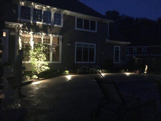 A house with a lot of windows is lit up at night