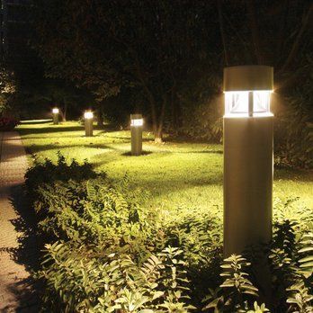 A row of lights are lit up in a park at night