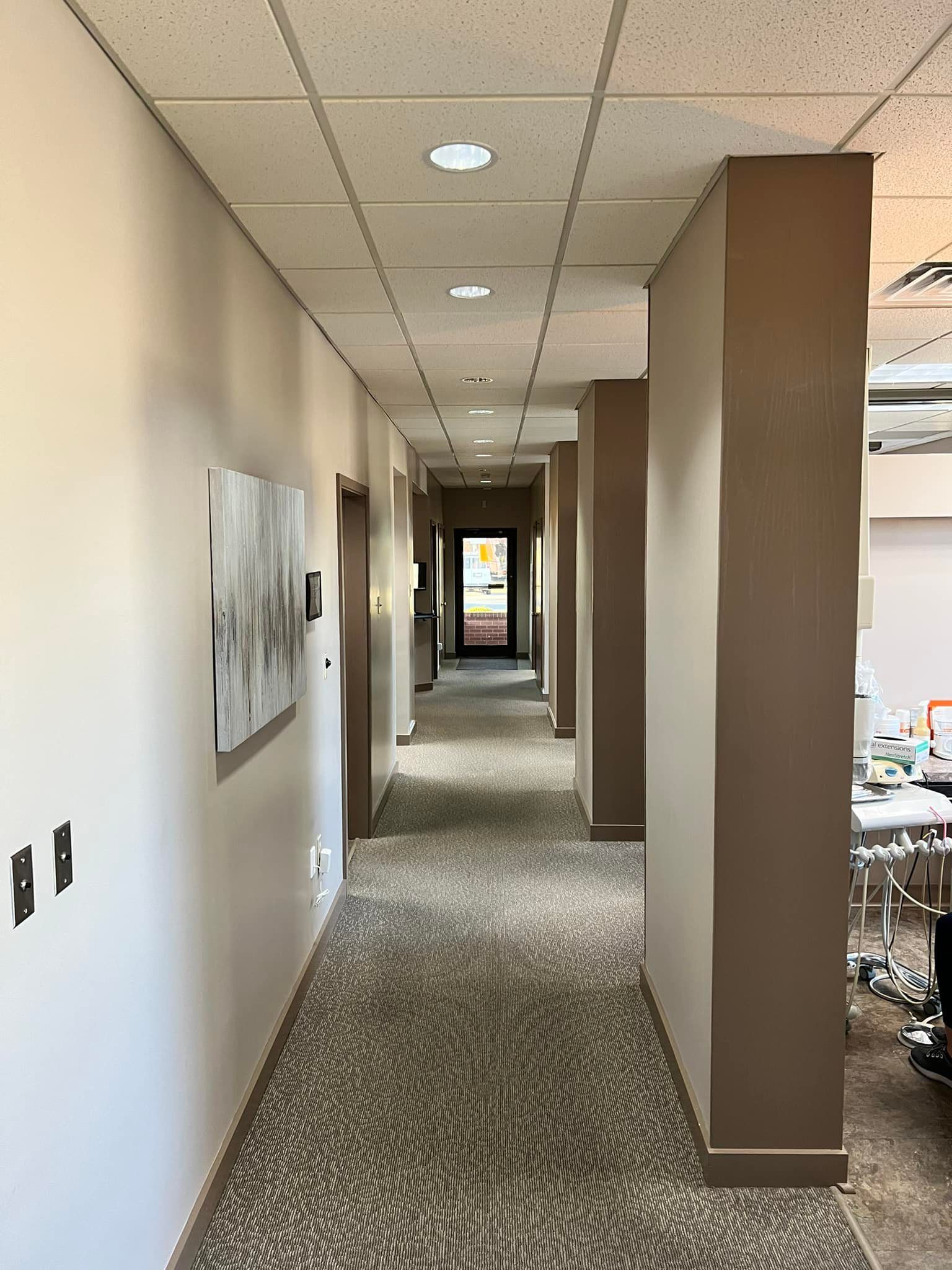 a long hallway in a building with a painting on the wall .