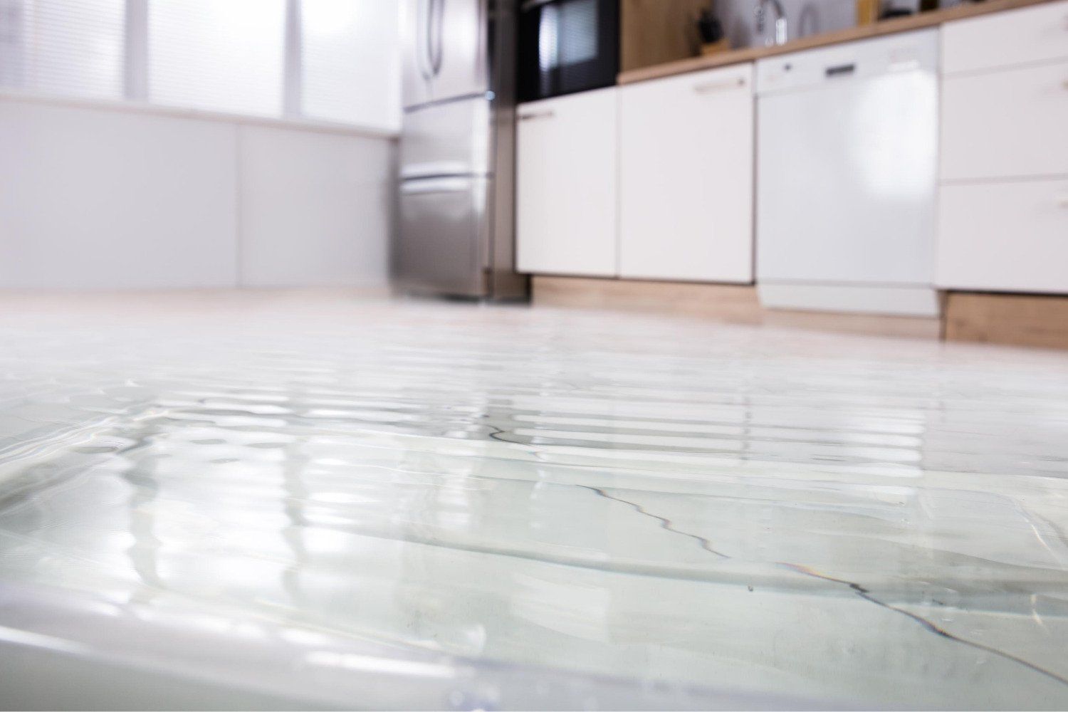 A kitchen floor with water coming out of it.