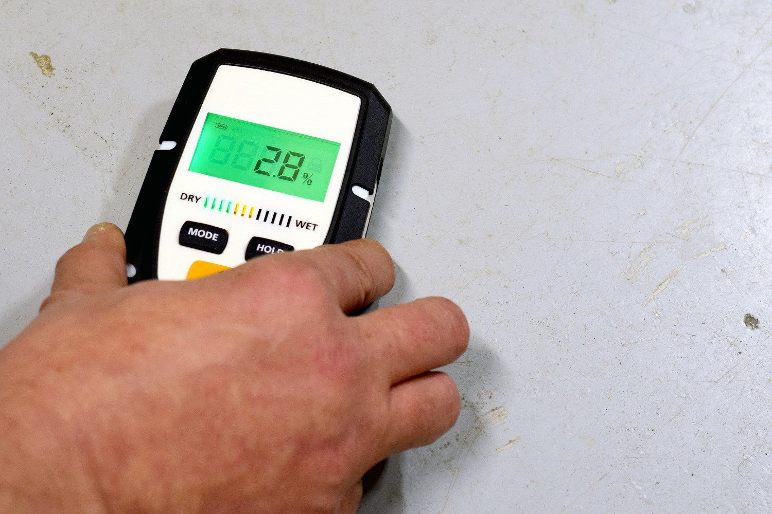 A hand is holding a digital device with the number 28 on the screen