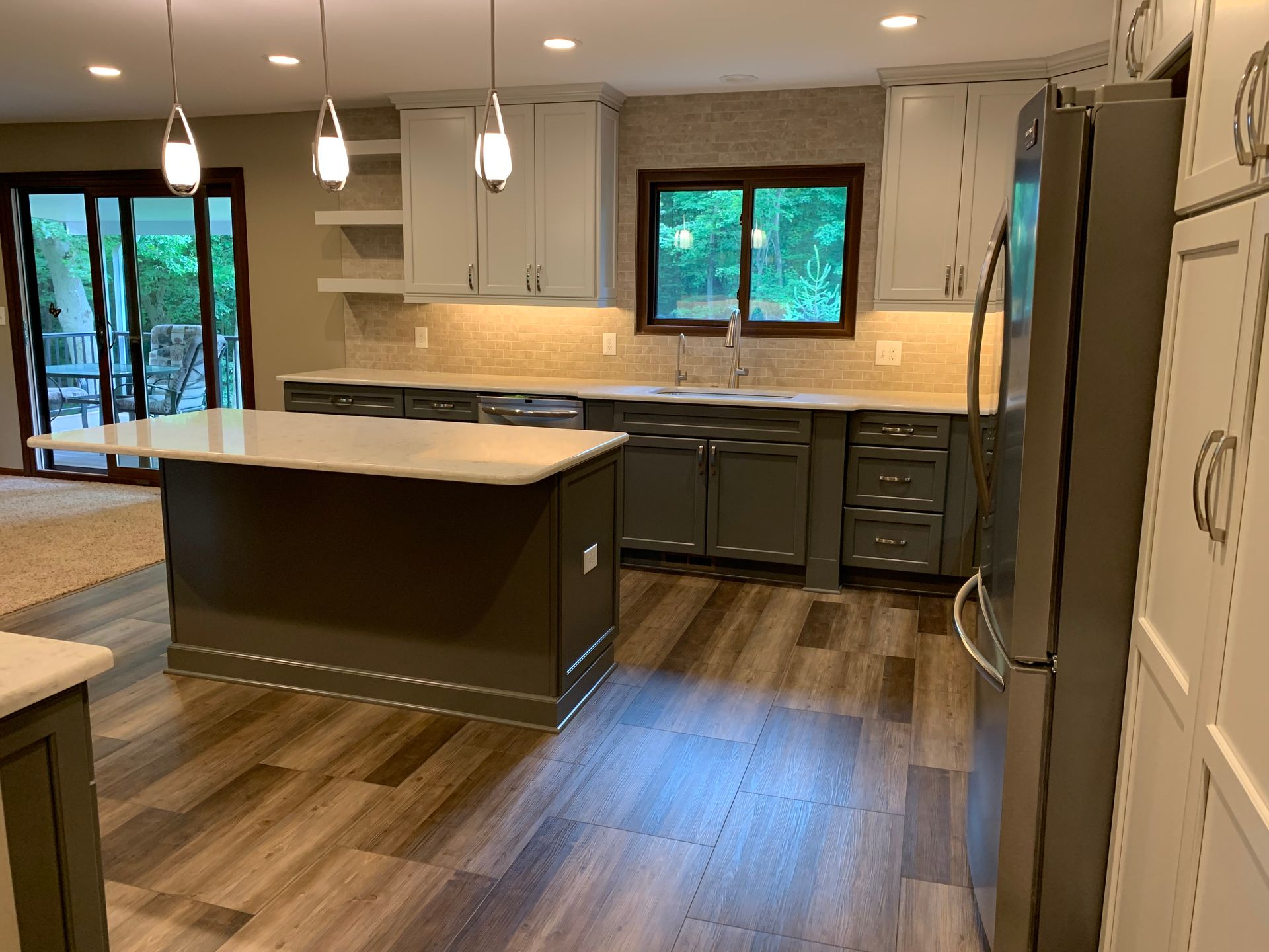 A Kitchen With Gray Cabinets , White Counter Tops , and a Refrigerator — Clarkston, Michigan — Hidden Lake Cabinet & Trim LLC