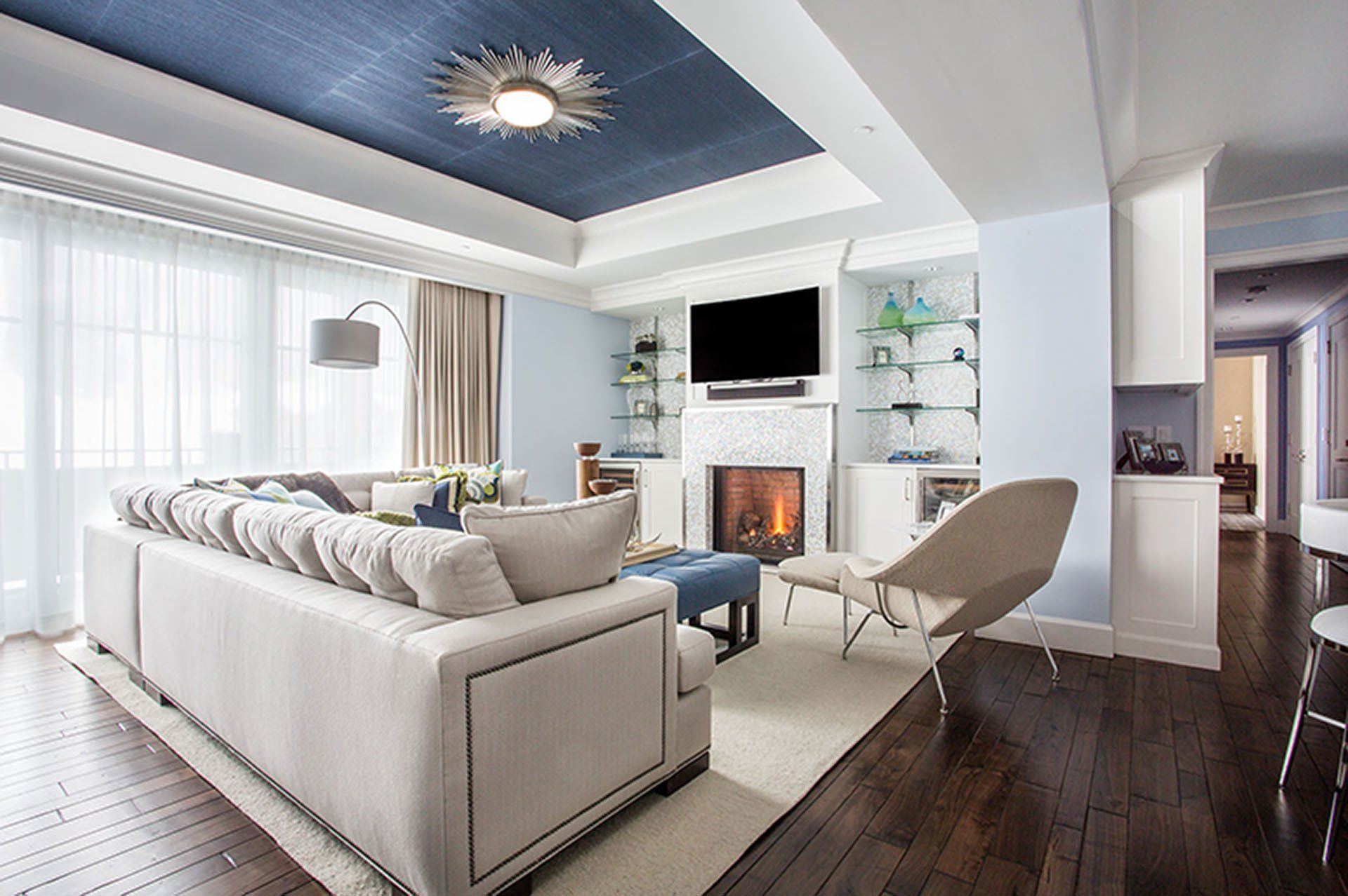 Living room with blue ceiling, fireplace, large sofa, and modern furniture.