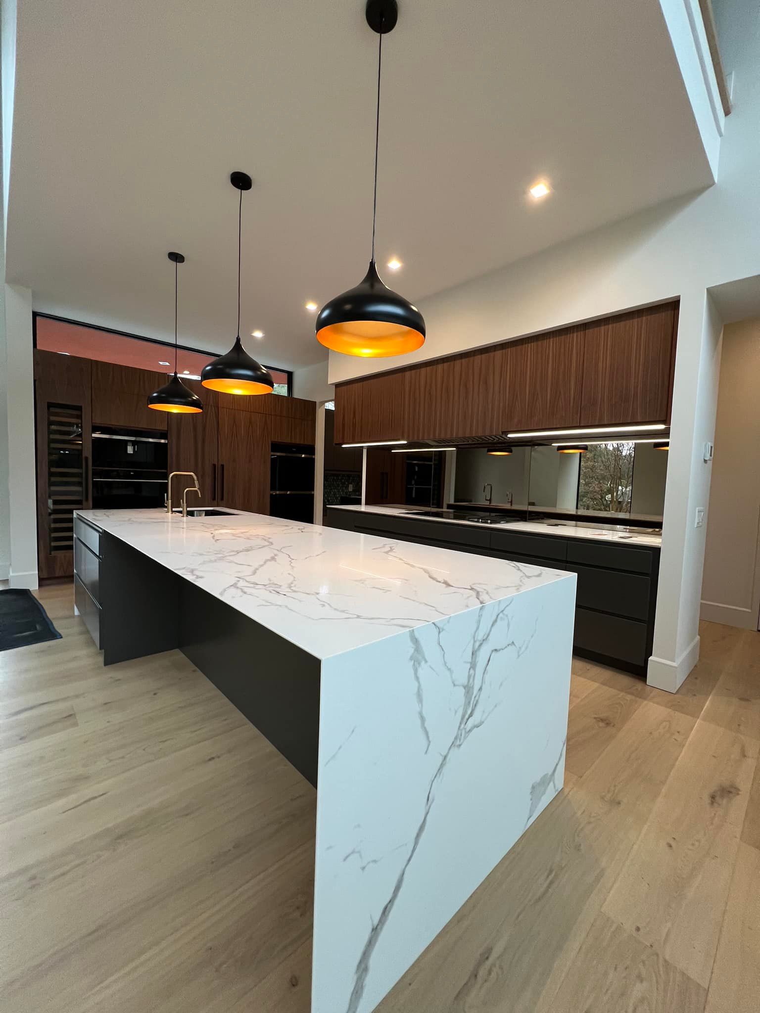 Modern kitchen with a large island and pendant lights.