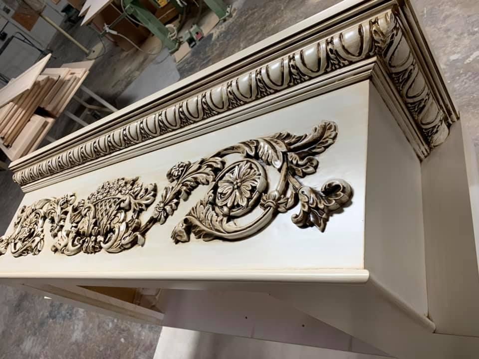 Cream-colored ornate wooden furniture with detailed carvings.