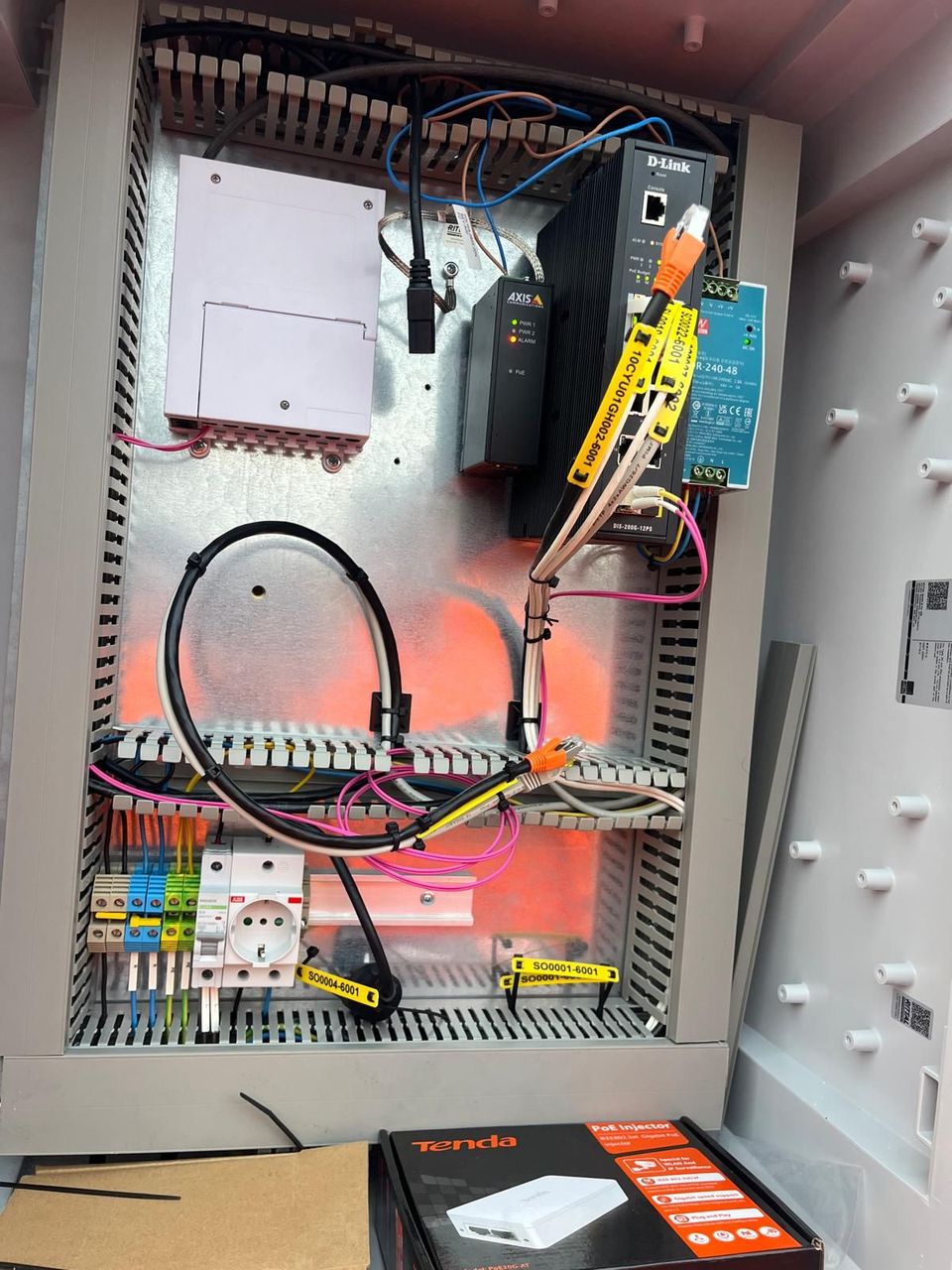 Open electrical control panel with wiring, relays, and circuit breakers inside a gray metal cabinet