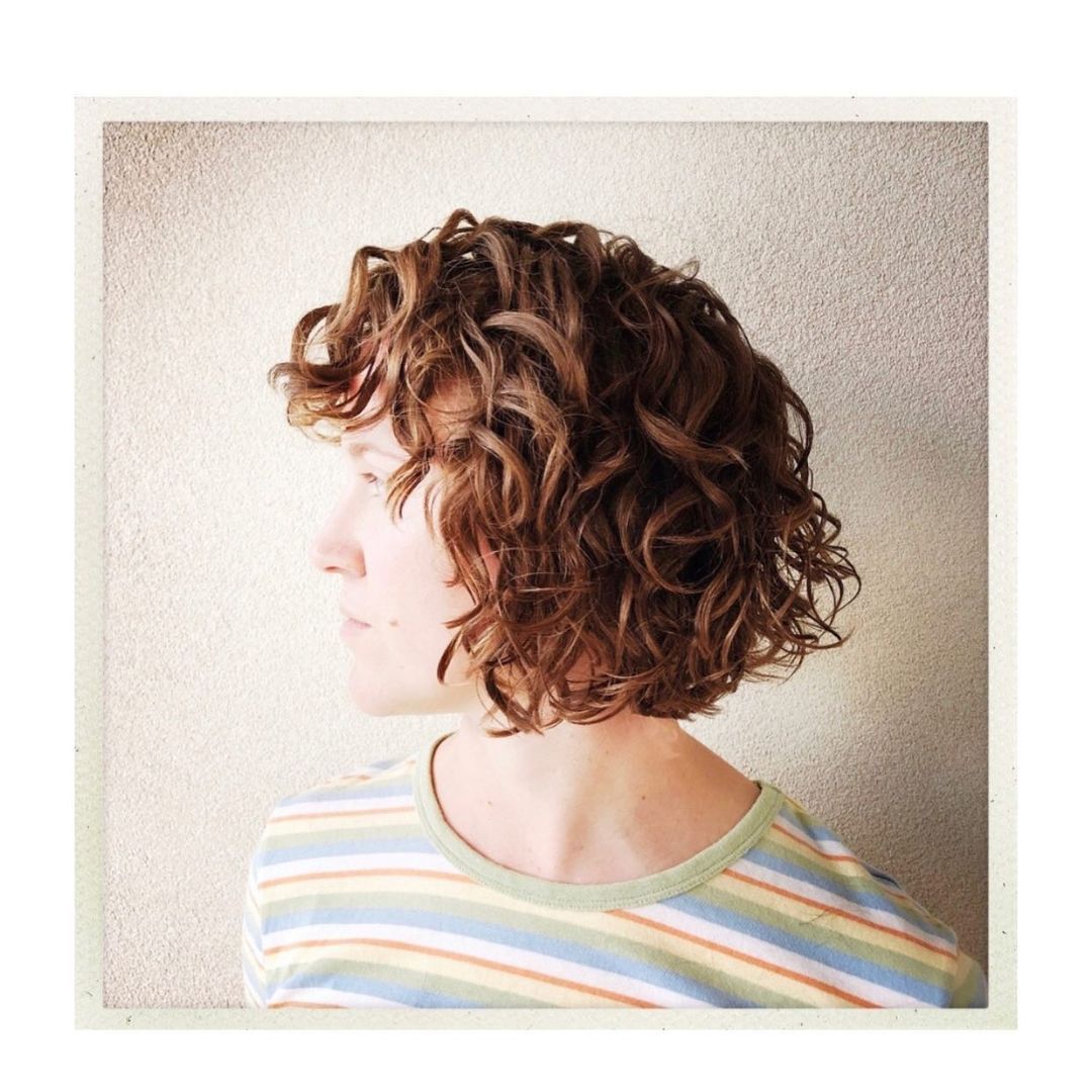A woman with curly hair is wearing a striped shirt