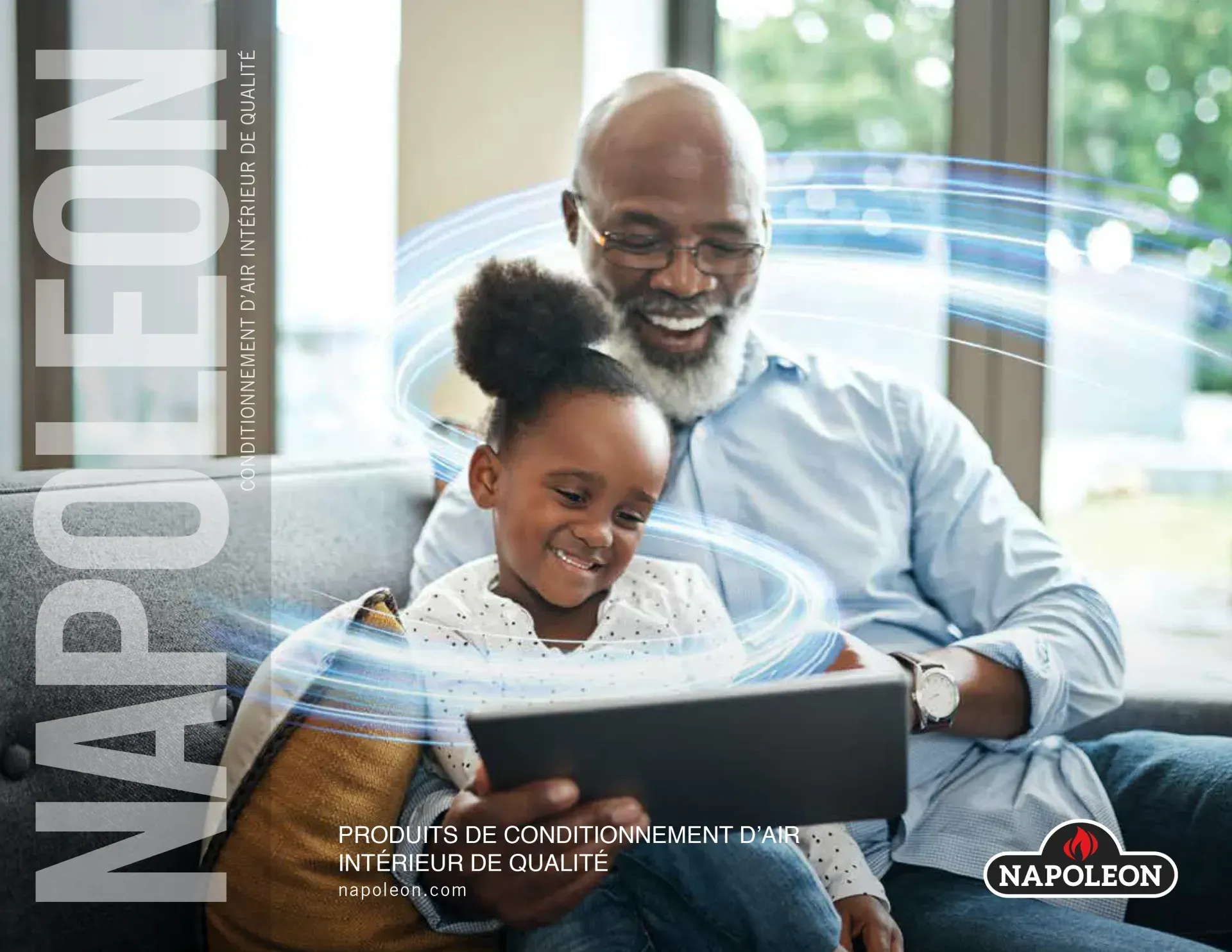 Un homme et une petite fille sont assis sur un canapé et regardent une tablette.