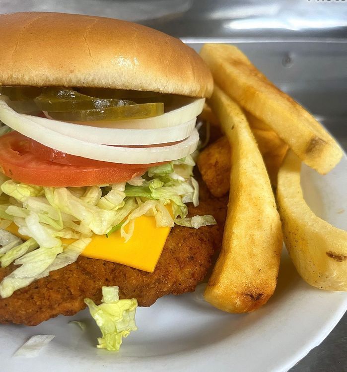 A white plate topped with a chicken sandwich and french fries