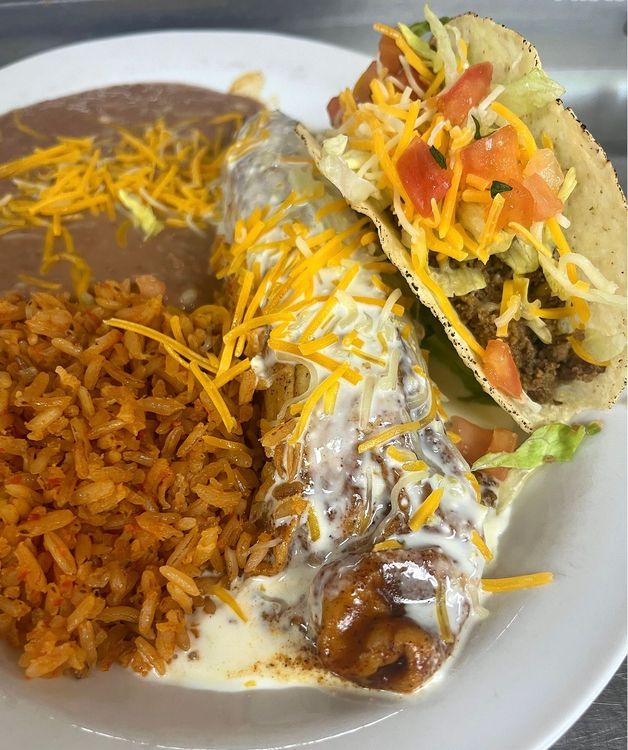 A white plate topped with a burrito , taco and rice.