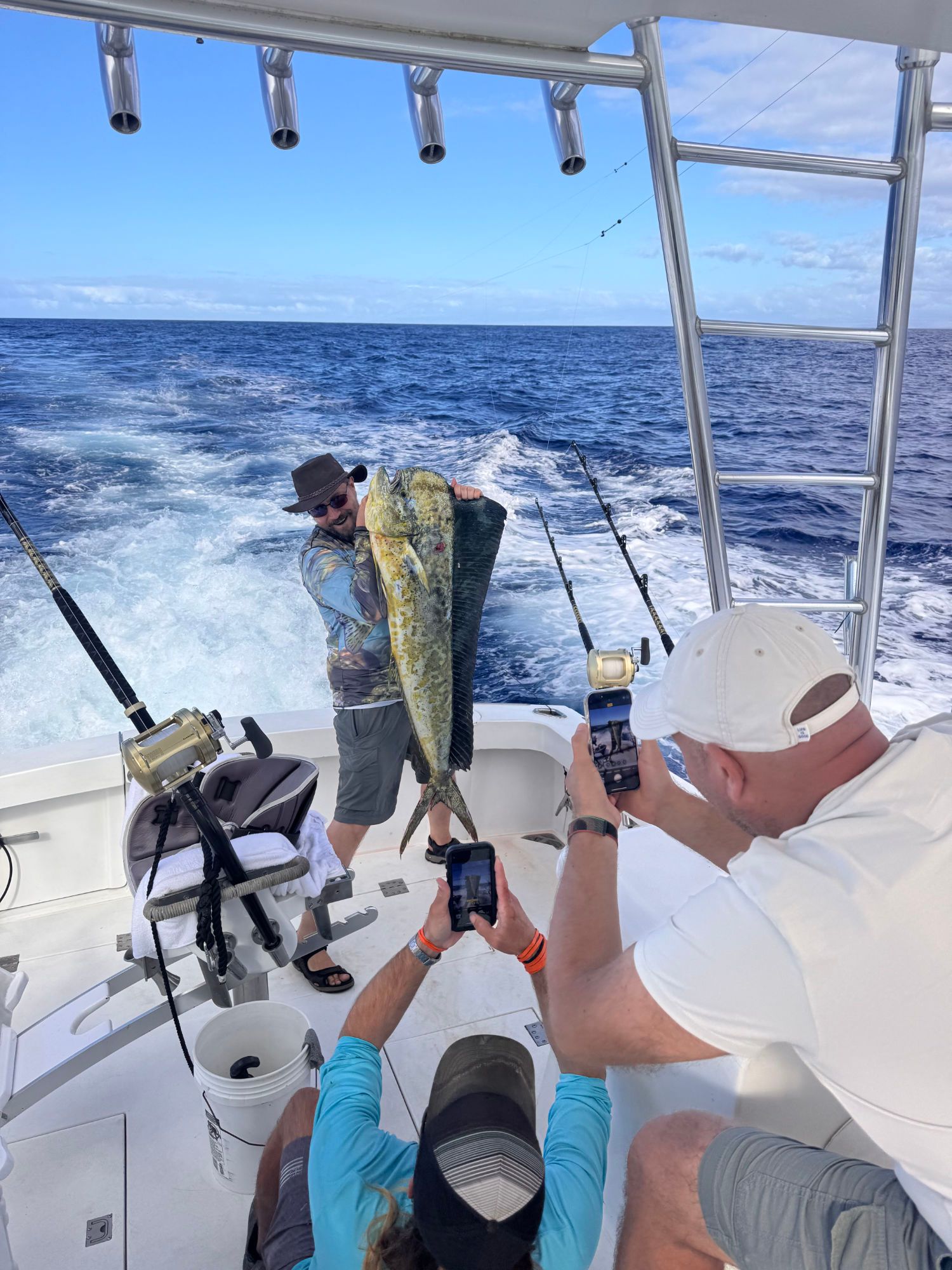 A man is holding a large fish on a boat