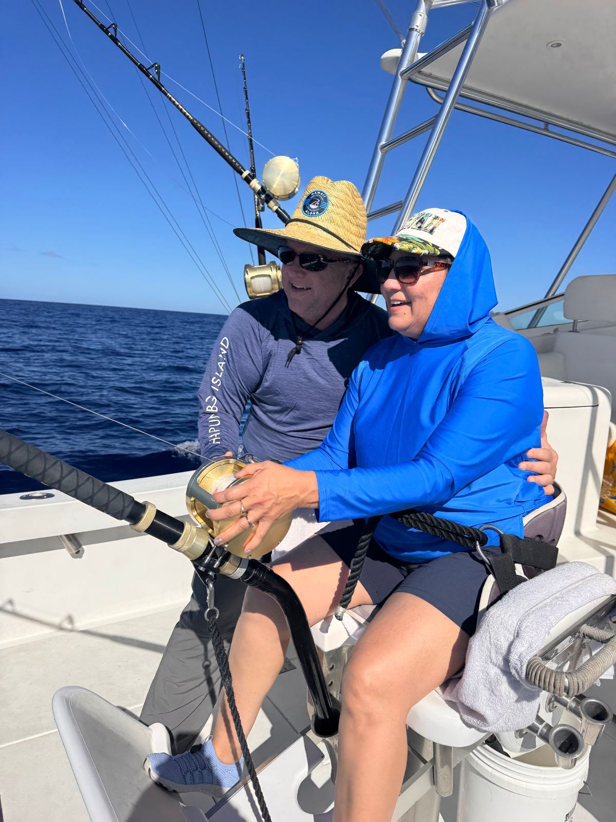 A man and a woman are fishing on a boat