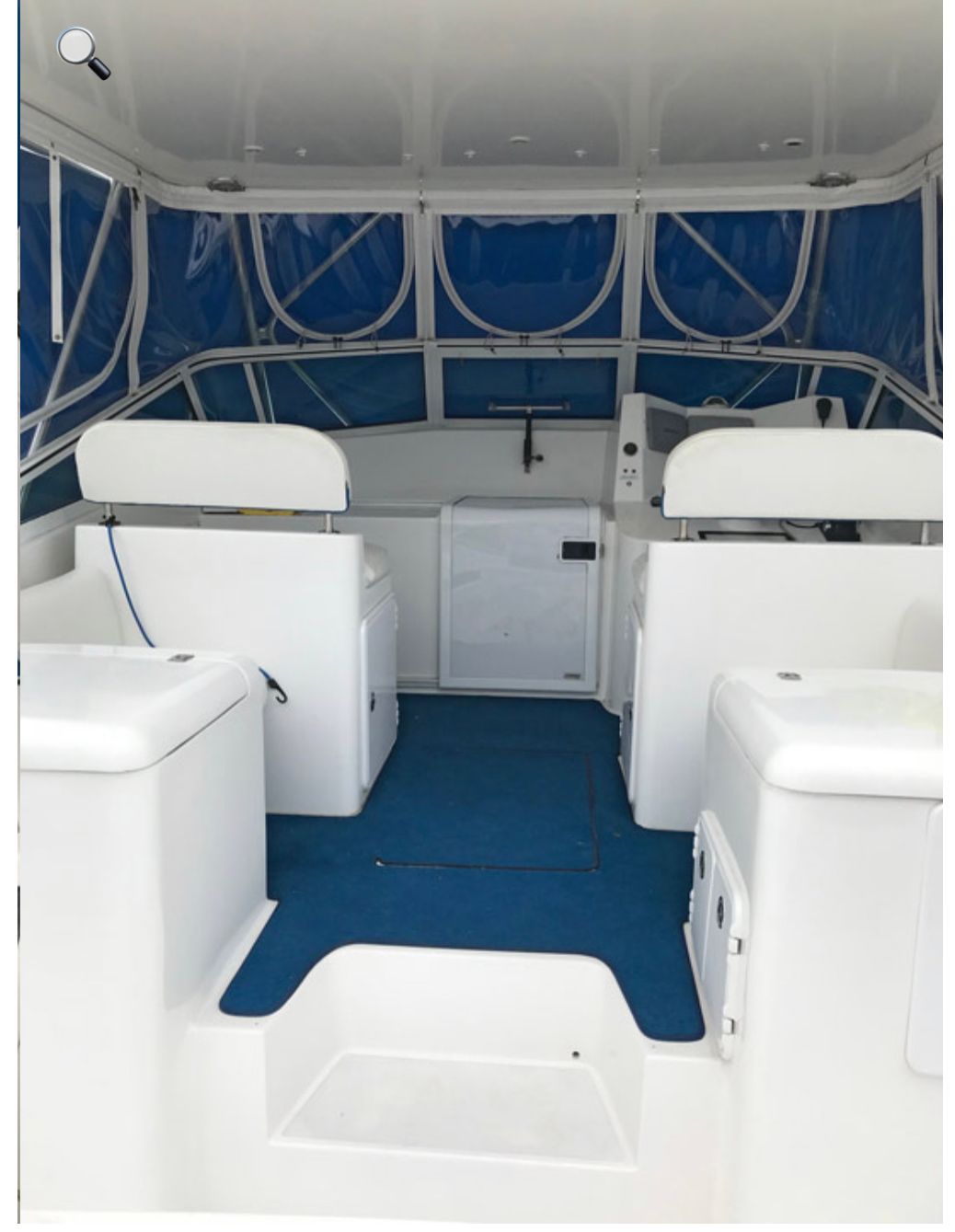 Cushioned bench seating on the boat's bridge under a canvas enclosure