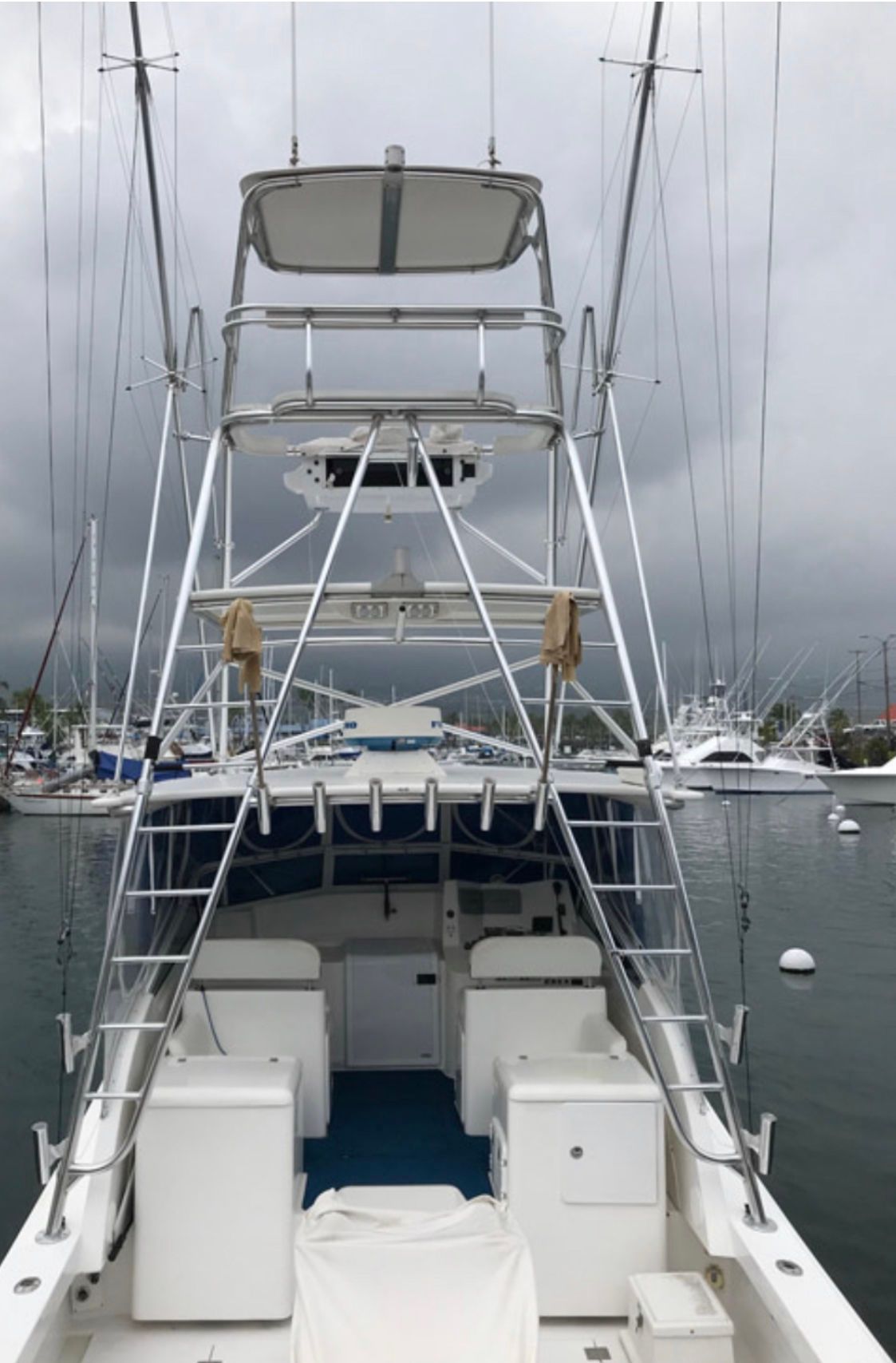Stern view of the 32 foot Topaz sportfishing boat with tuna tower and outriggers docked at Honokohau Harbor