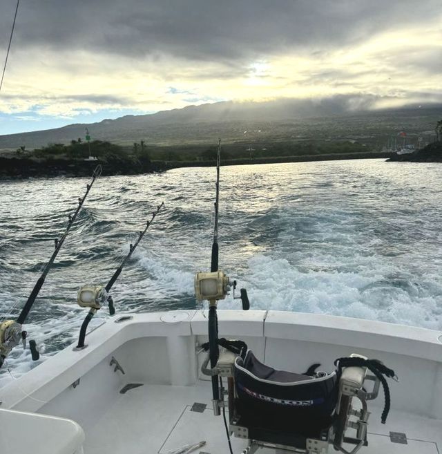 A boat with fishing rods and a chair on the deck