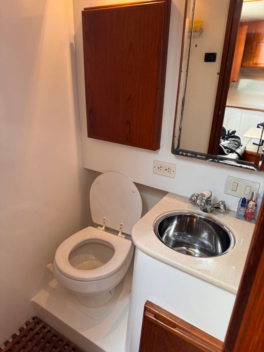 Enclosed head with a vacuflush toilet sink, and mirror