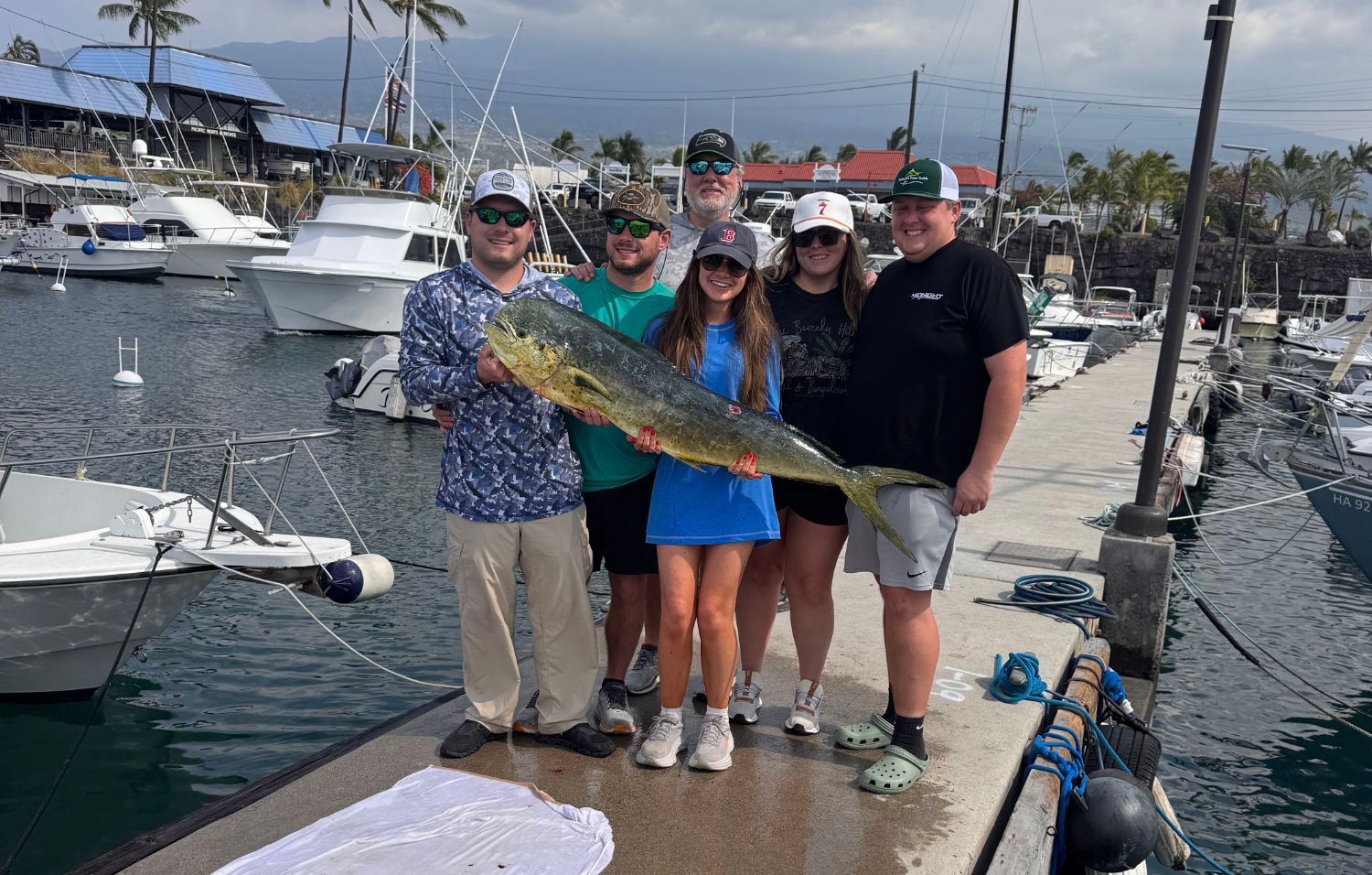 A group of people standing on a dock holding a fish