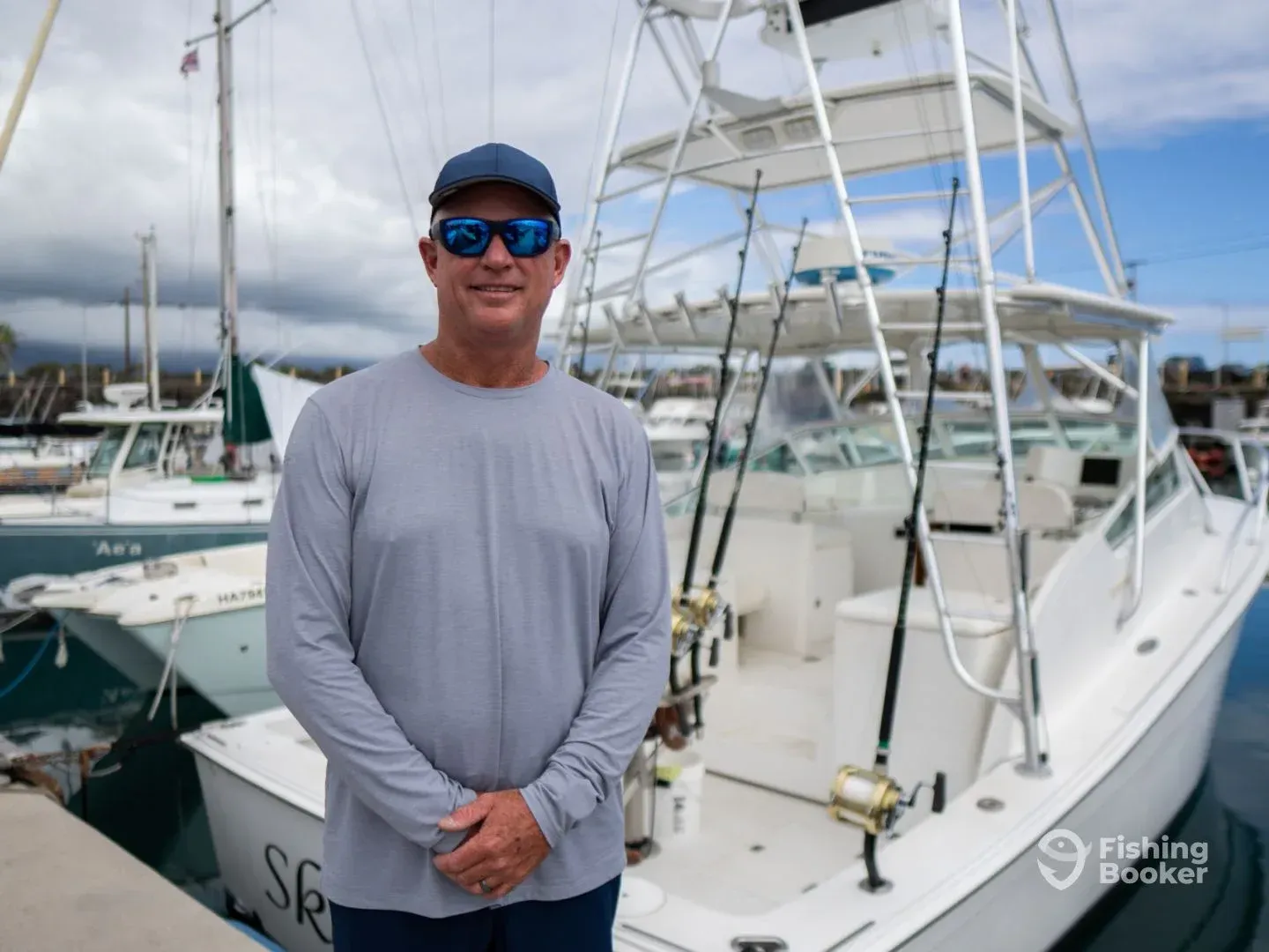 A man wearing sunglasses is standing in front of a boat.