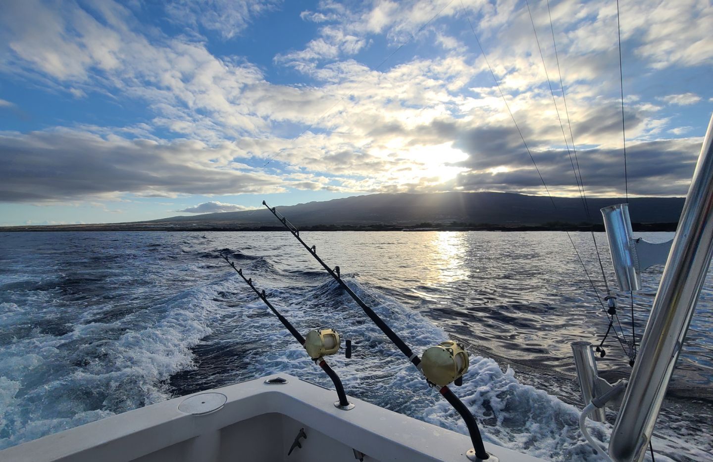 A boat fishing boat on the water with the Big Island of Hawaii in the background