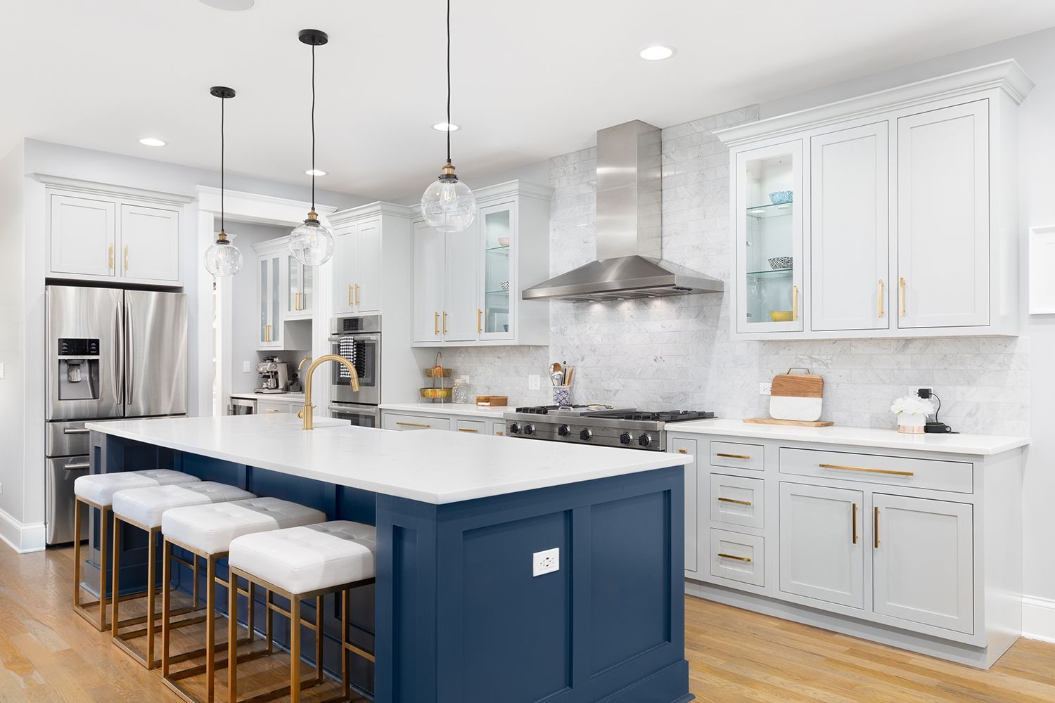 Bright modern kitchen with white cabinets, blue island, and stainless steel appliances Bright modern kitchen with white cabinets, blue island, and stainless steel appliances