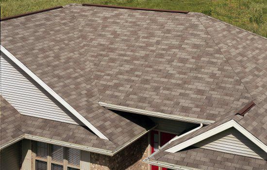 Damaged roof with missing shingles and a torn section exposing the attic below