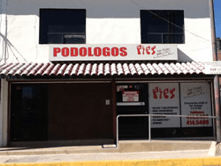 Un edificio blanco con un cartel que dice podlogos pies