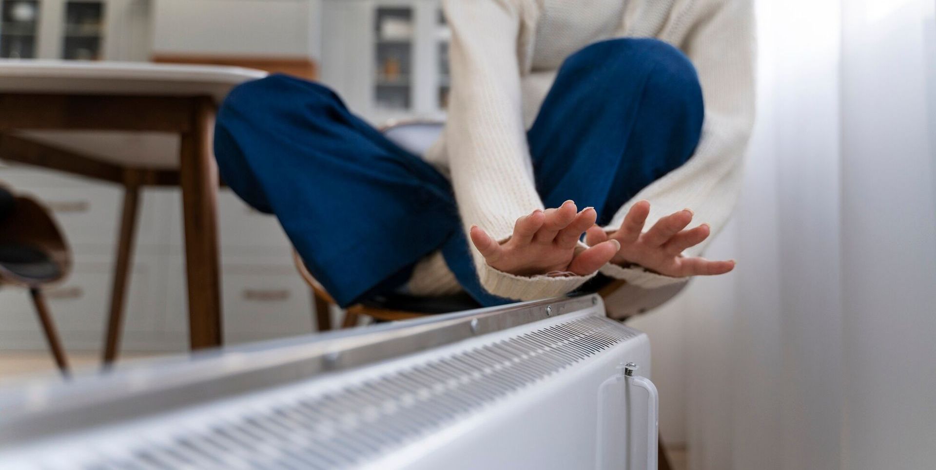 Unité de climatisation fixée sur un mur blanc dans un salon baigné de lumière naturelle.