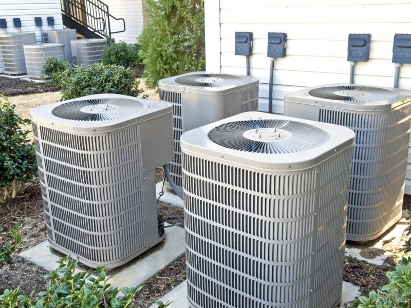 Un groupe de climatiseurs est installé à l'extérieur d'un bâtiment.