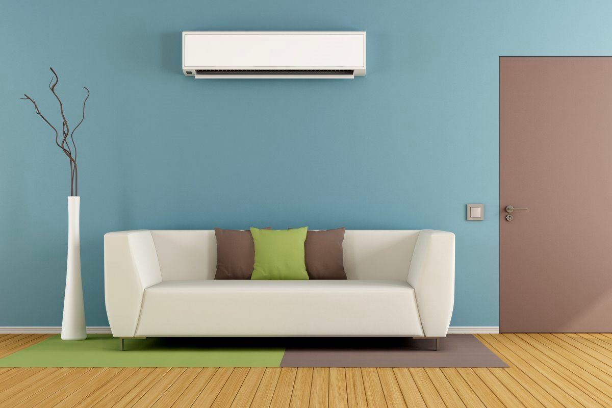 Un salon avec un canapé et un climatiseur au mur
