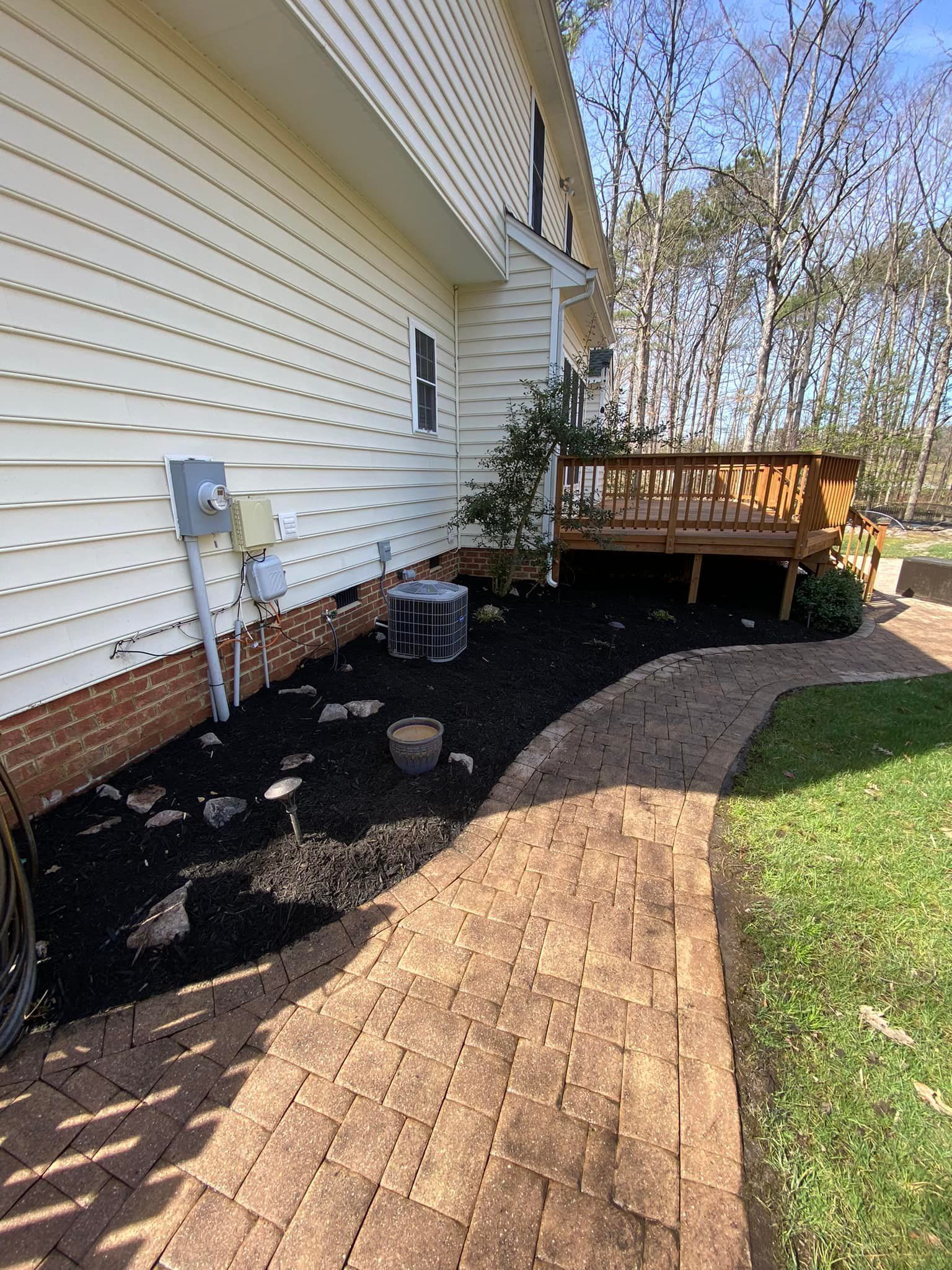 There is a walkway leading to the backyard of a house.