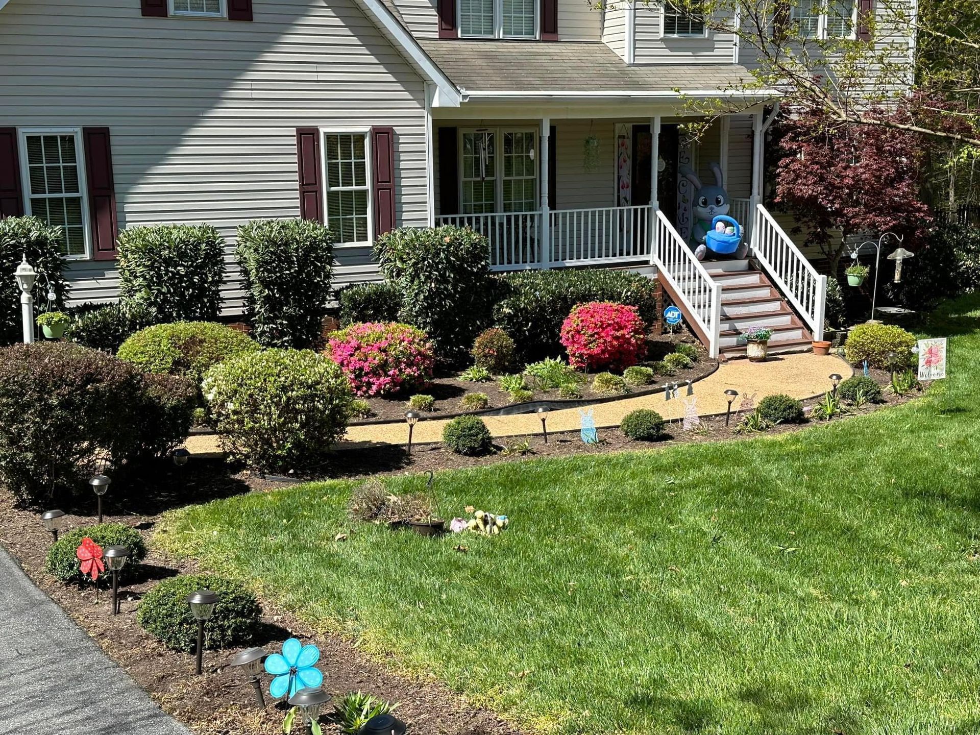 A house with a lush green lawn and a walkway leading to the front door.