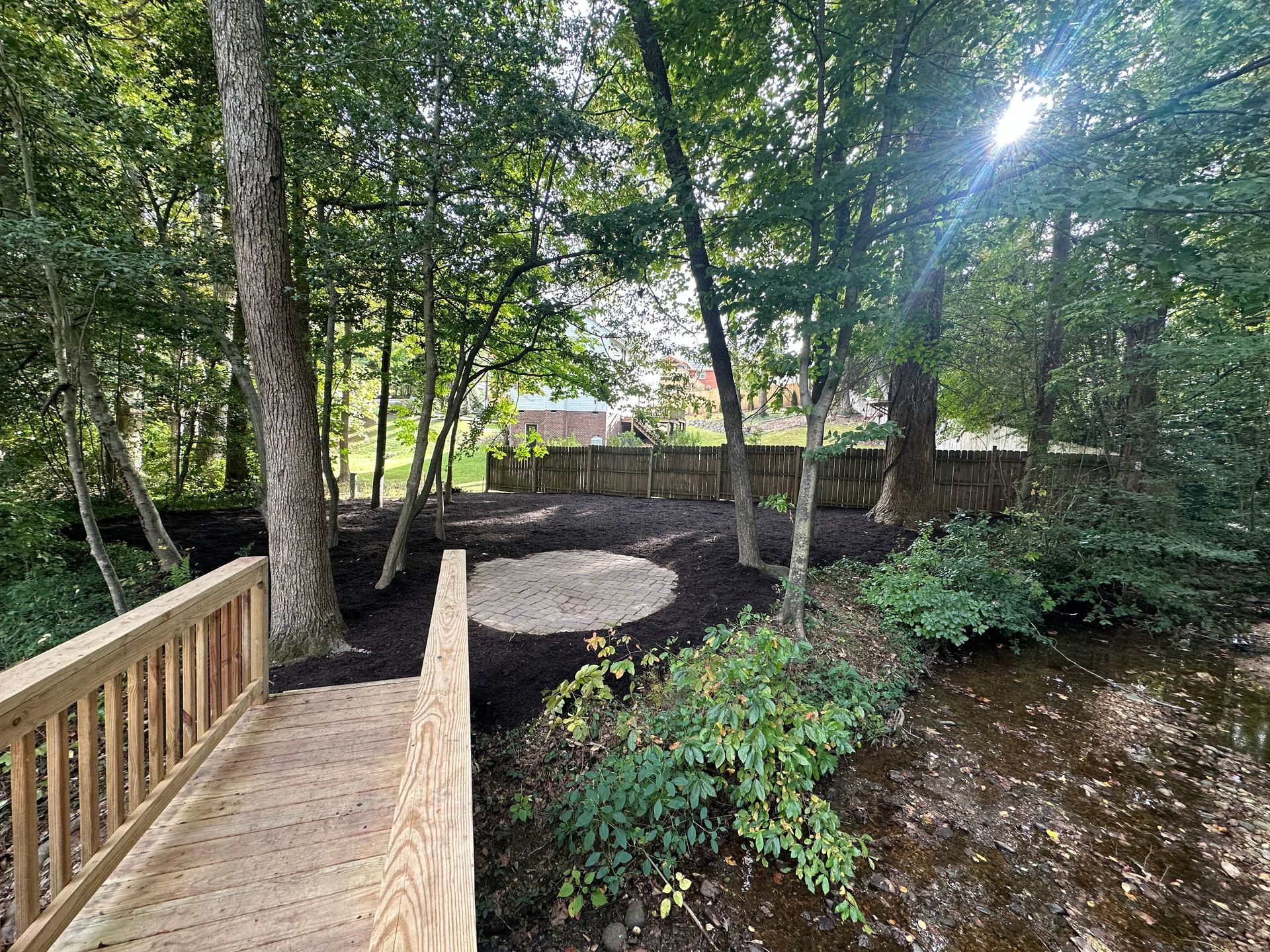 A wooden bridge over a stream in the woods.