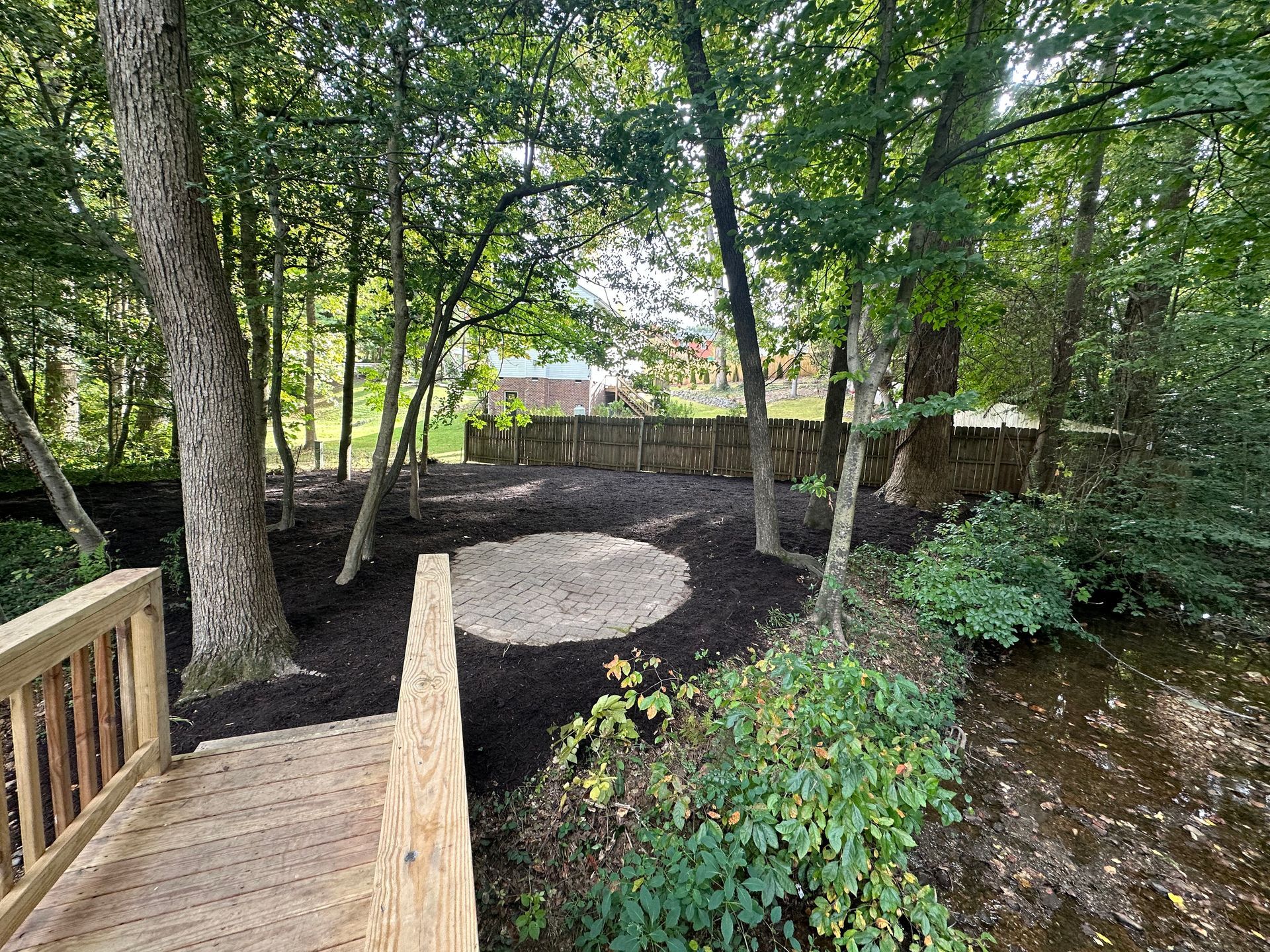 A wooden bridge over a stream in the middle of a forest.