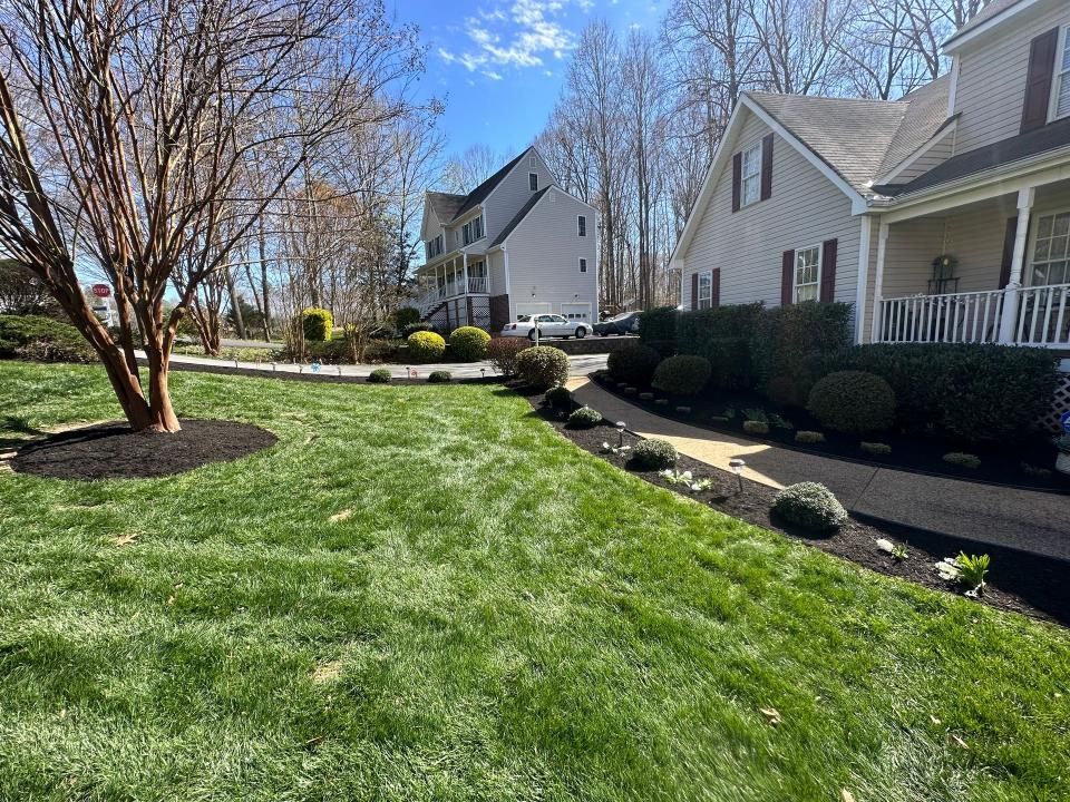 A lush green lawn in front of a white house.