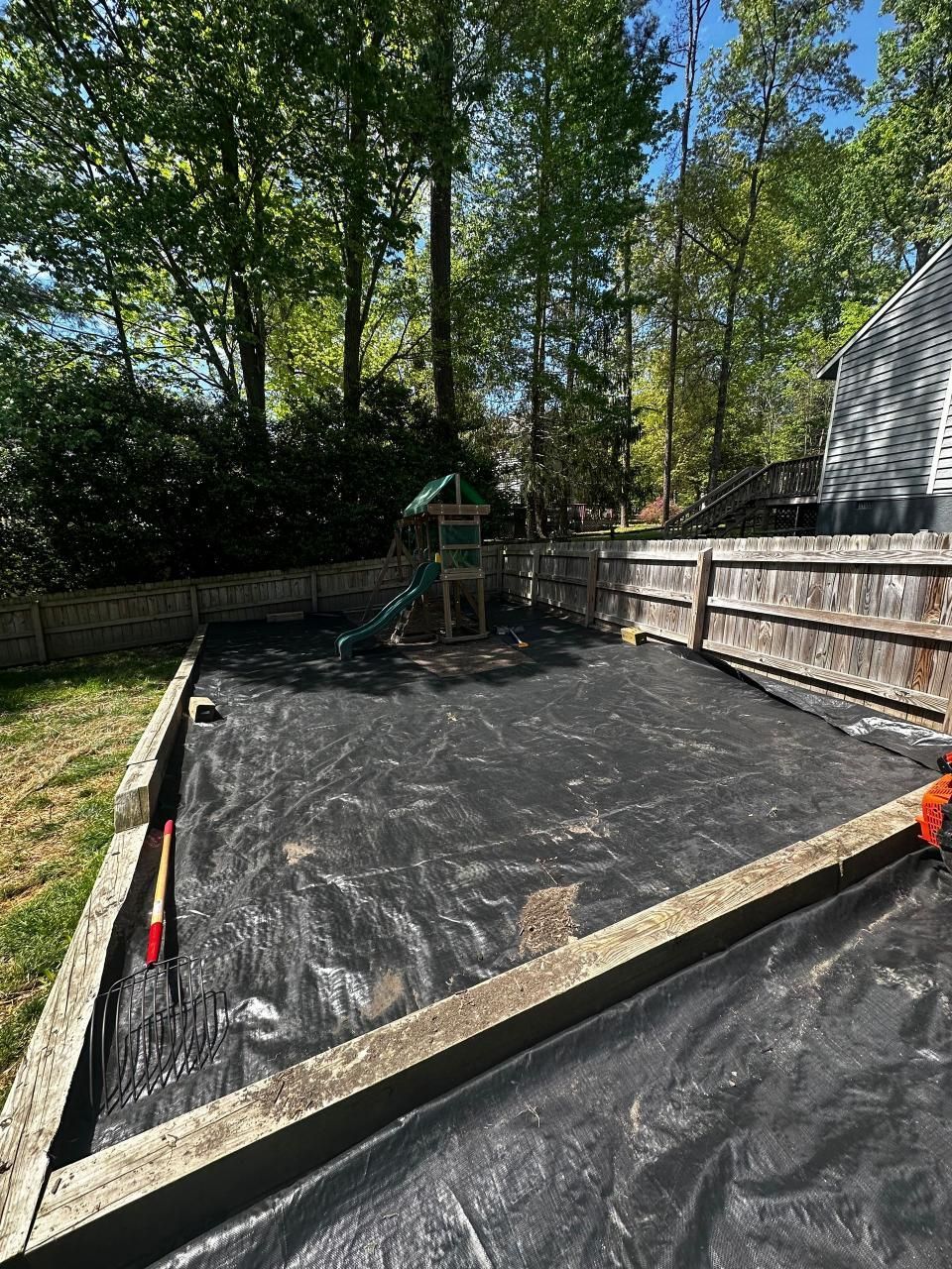 A playground is being built in the backyard of a house.