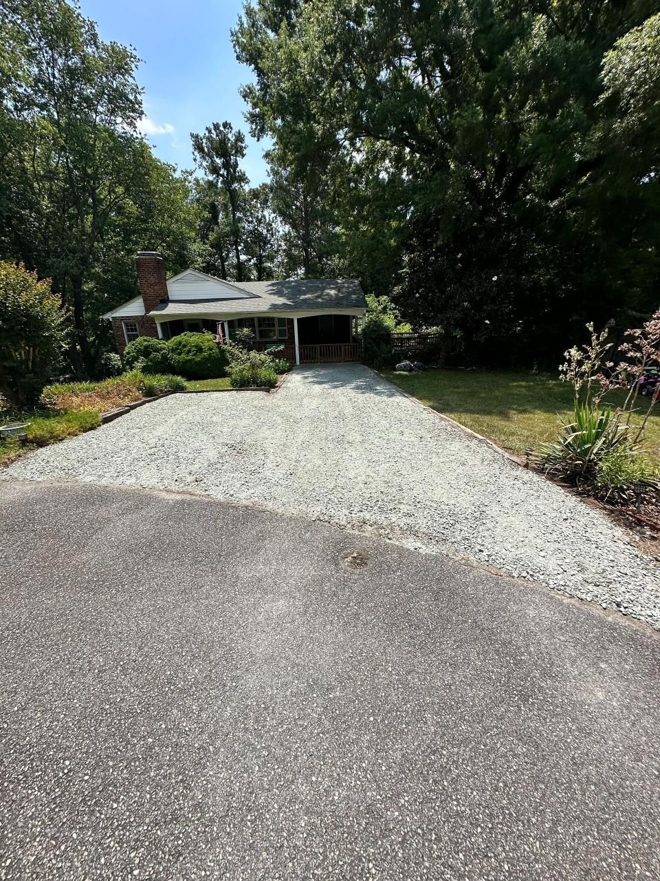 A driveway leading to a house surrounded by trees