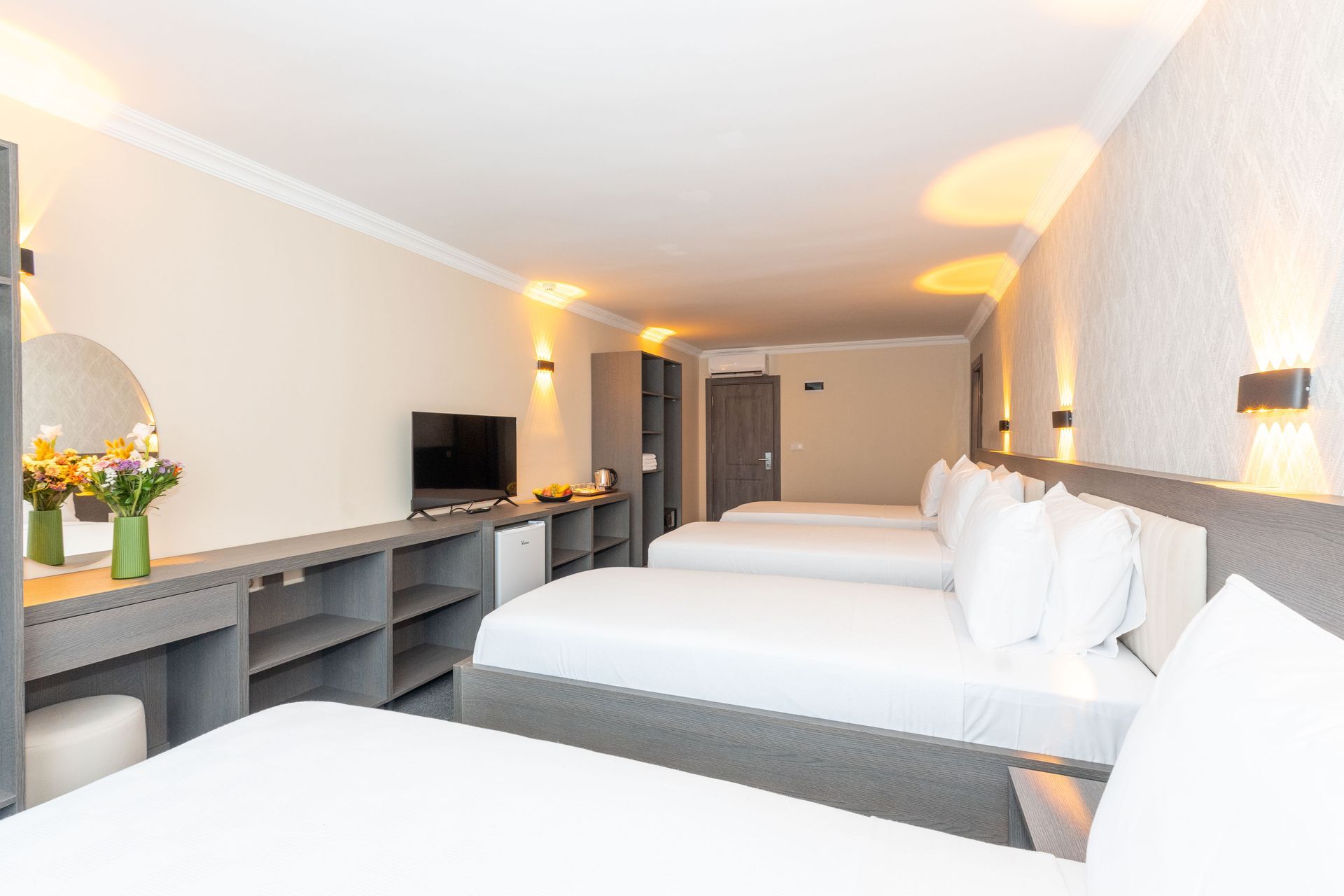 Mays Otel | Hotel room with four beds, neutral colors, small TV, and a vanity.