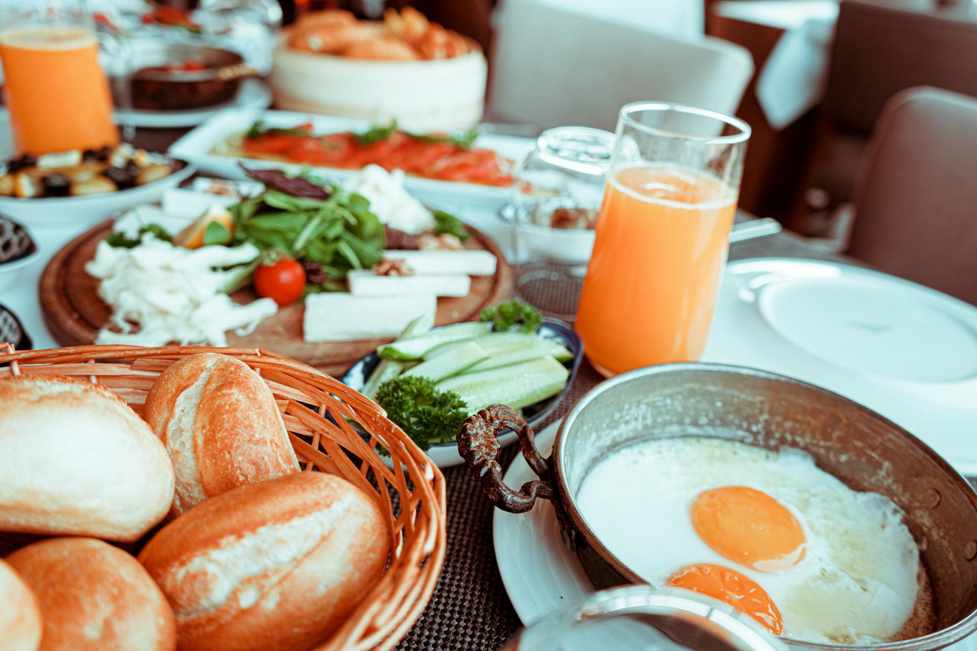 Mays Otel | Breakfast table laden with bread, cheese, eggs, juice, and other assorted dishes.
