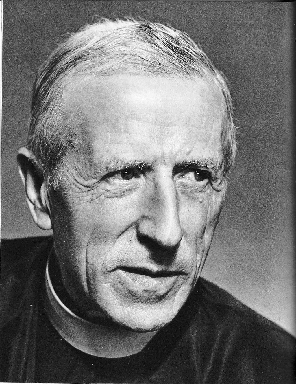 Black-and-white portrait of a man in clerical clothing, facing left with a serious expression.